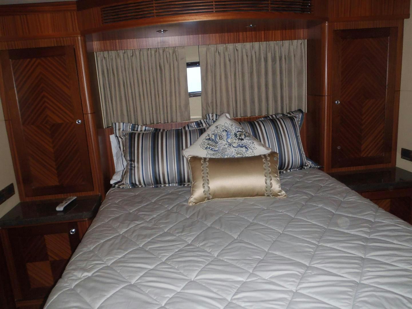 a bed with a white comforter and pillows aboard CLAYPEN Yacht for Sale