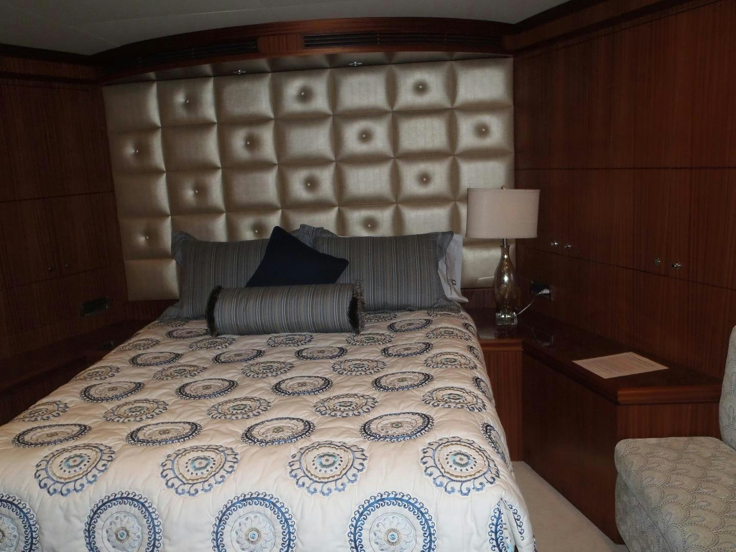 a bed with a blue and white comforter and pillows aboard CLAYPEN Yacht for Sale