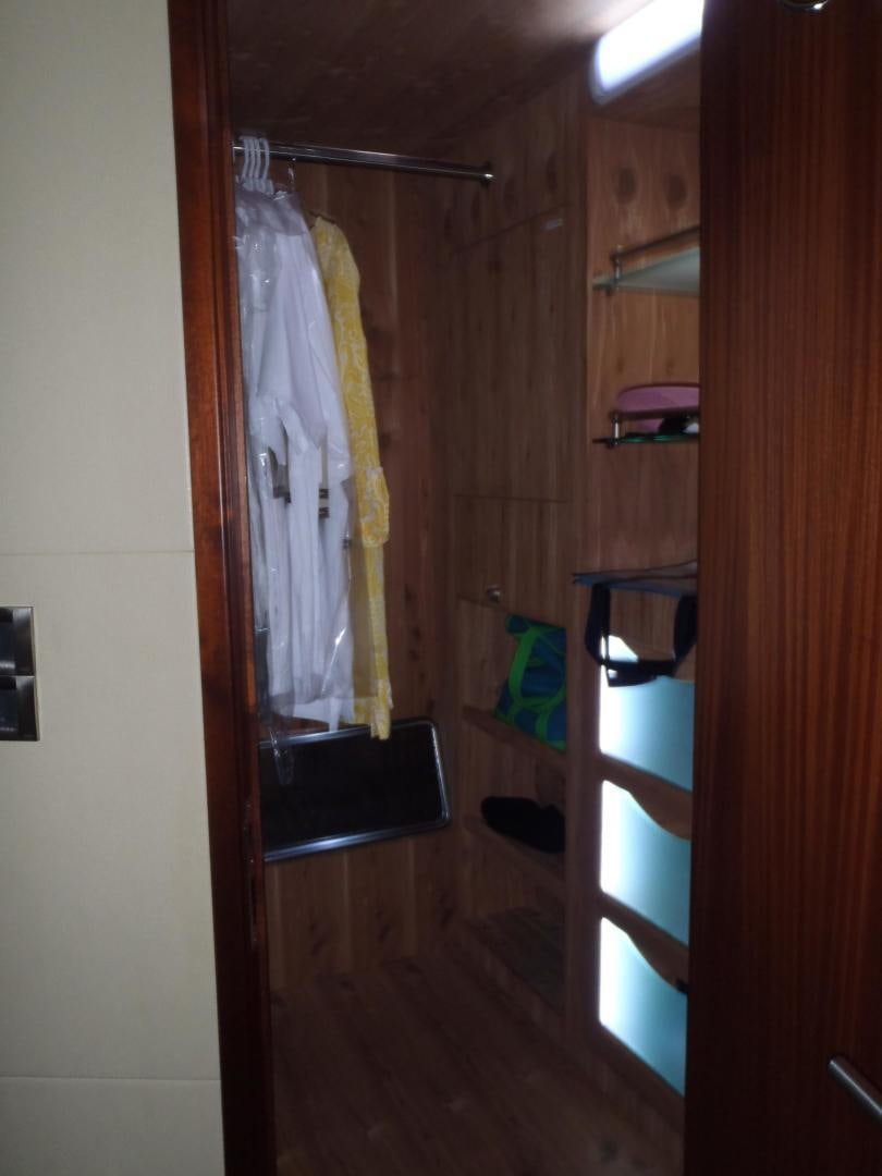 a closet with clothes on the wall aboard CLAYPEN Yacht for Sale