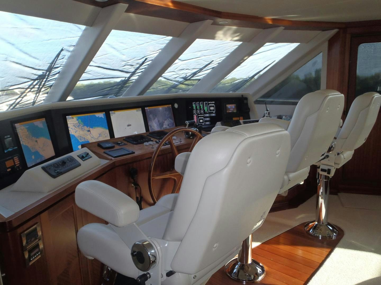 a white chair in a room with many screens aboard CLAYPEN Yacht for Sale