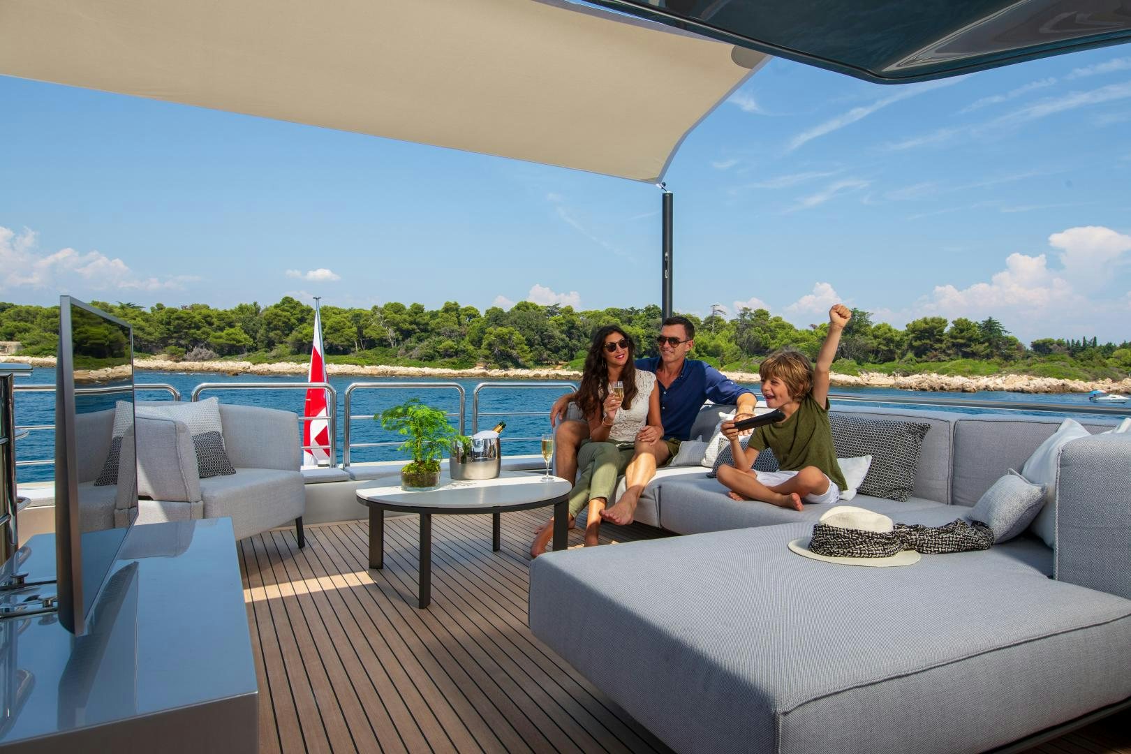 a group of people sitting on a couch on a deck with a flag aboard URSUS V Yacht for Sale