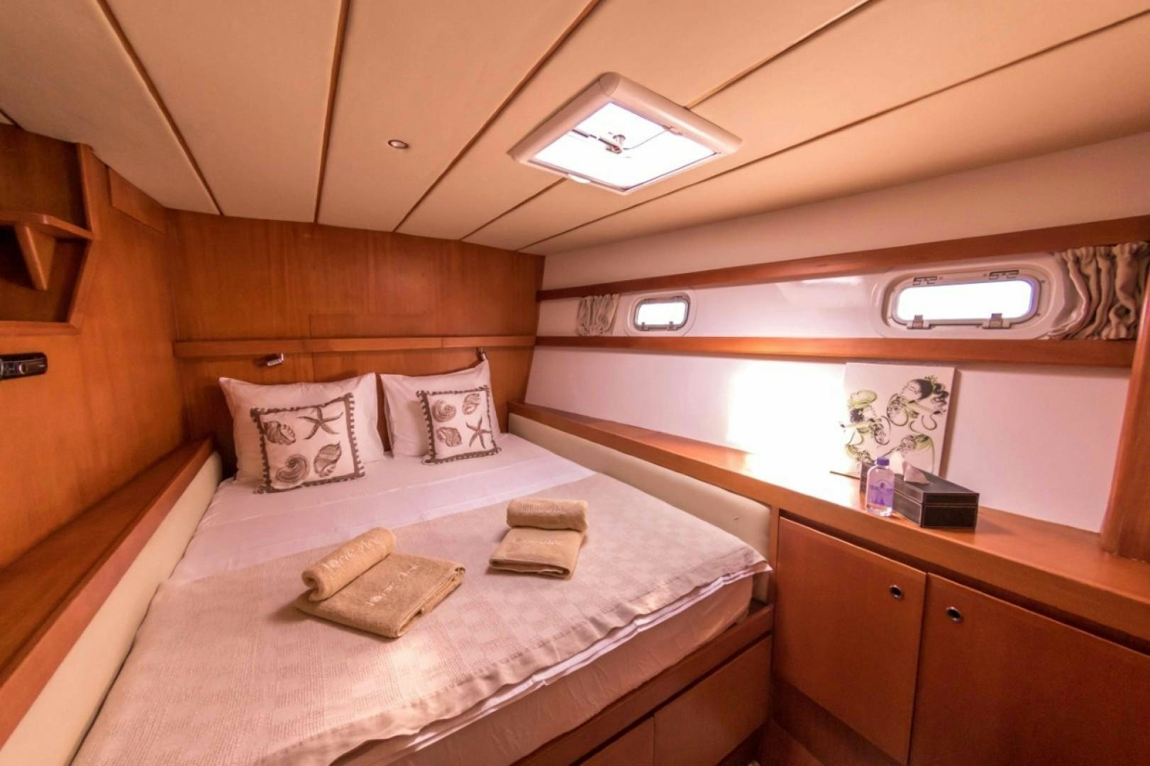 a bed with white sheets and pillows aboard LONESTAR Yacht for Sale