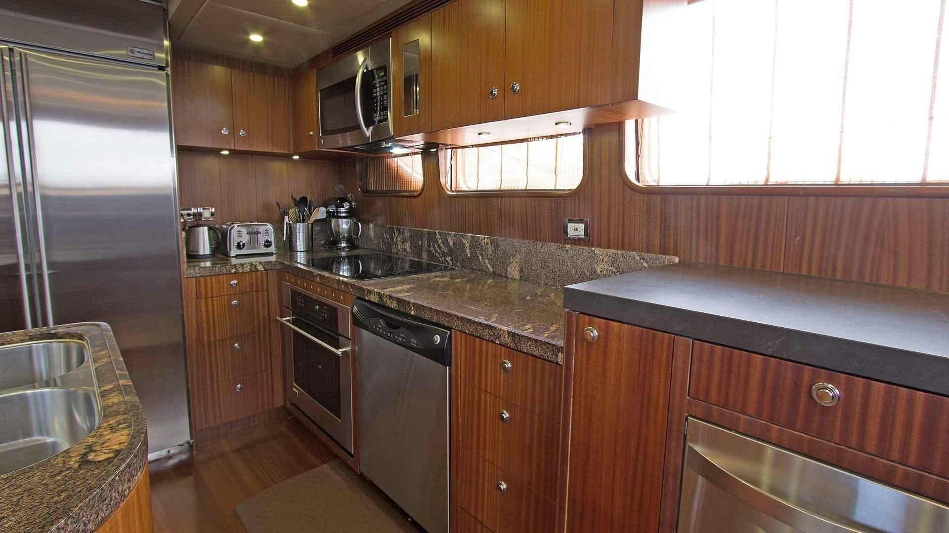 a kitchen with wooden cabinets aboard JUS CHILL'N Yacht for Sale