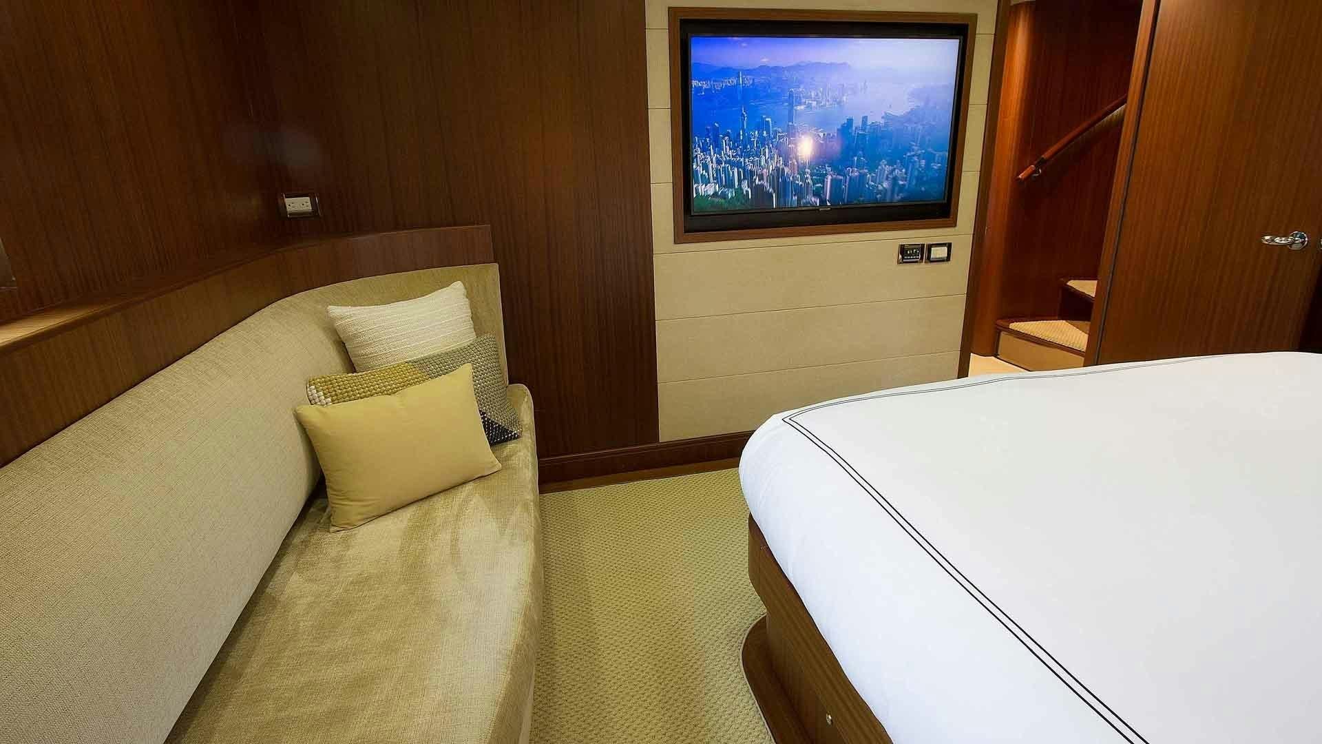 a room with a bed and a tv on the wall aboard JUS CHILL'N Yacht for Sale