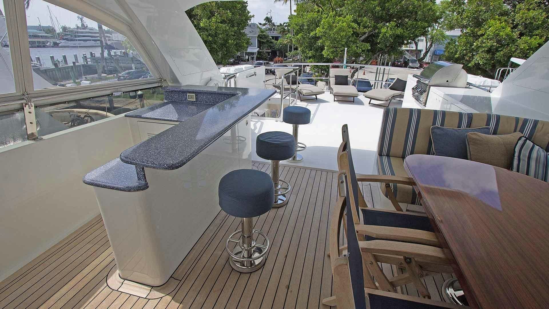a deck with a table and chairs aboard JUS CHILL'N Yacht for Sale