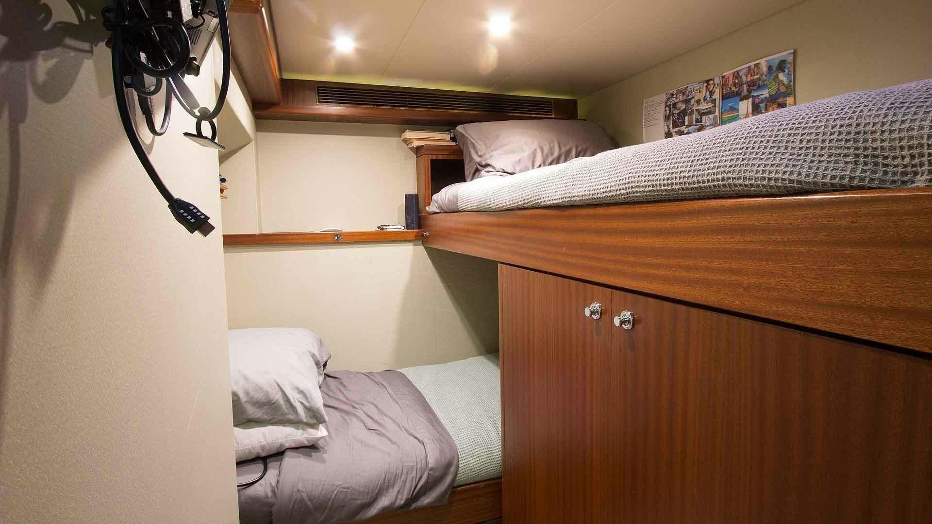 a bedroom with a bed and a dresser aboard JUS CHILL'N Yacht for Sale