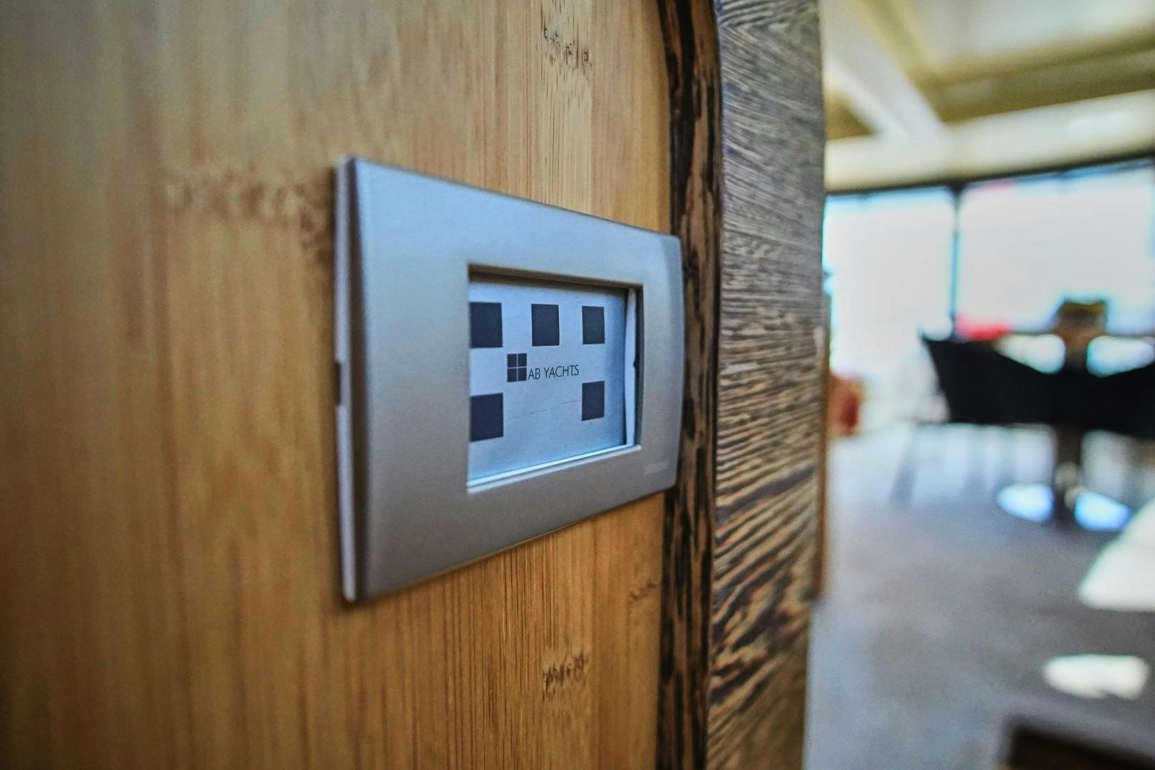 a rectangular electronic device on a wood surface aboard SYBER Yacht for Sale