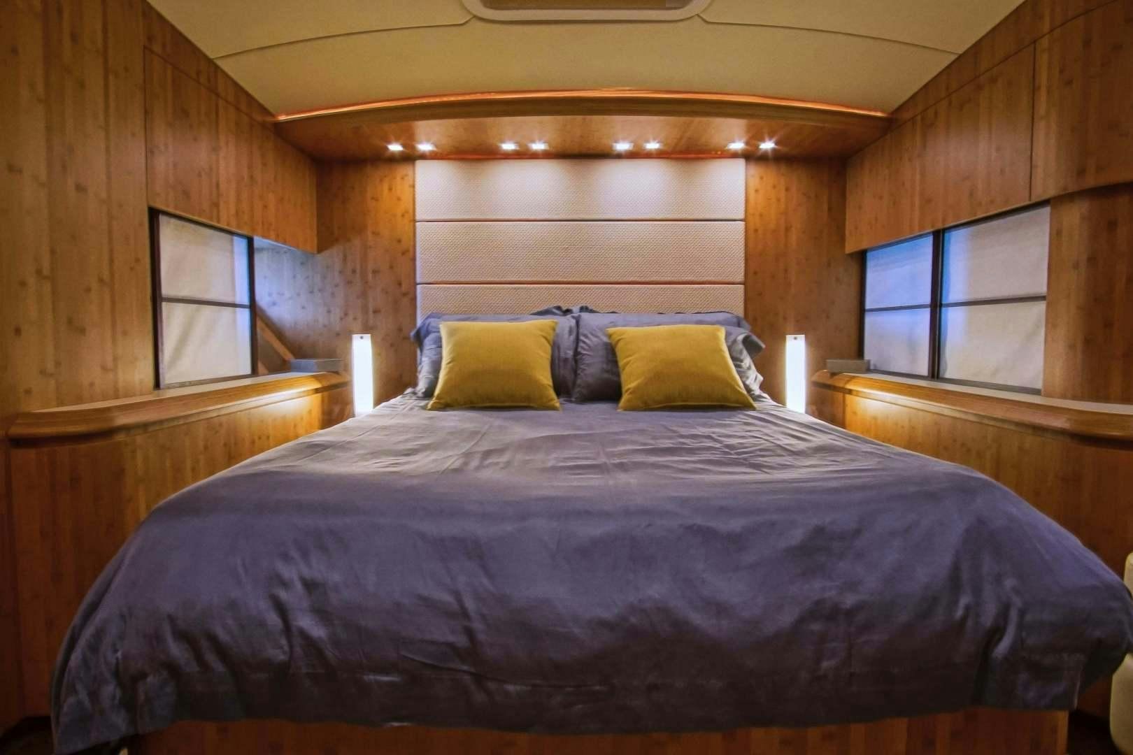 a bed with a purple comforter aboard SYBER Yacht for Sale