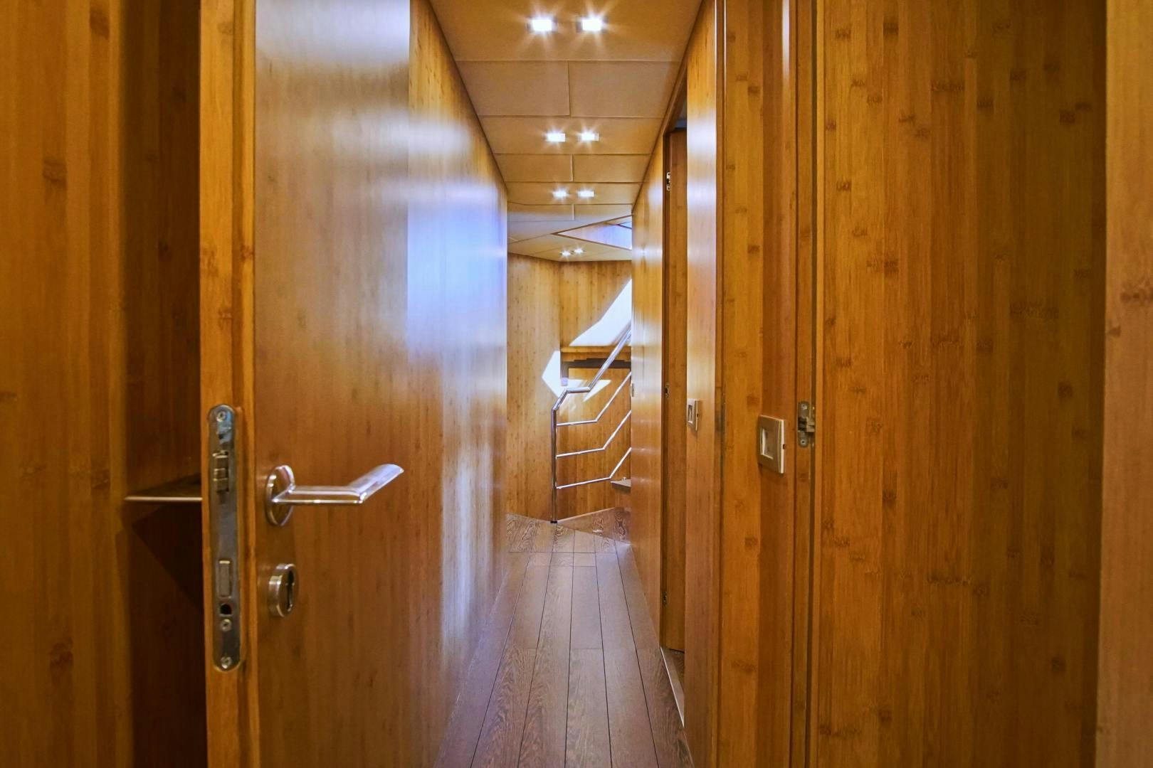 a wooden hallway with wooden doors aboard SYBER Yacht for Sale