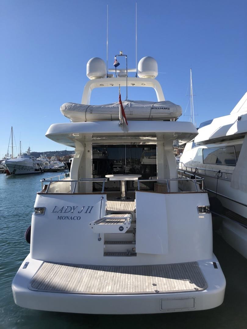 a white boat with a red stripe on it aboard LADY J II Yacht for Sale