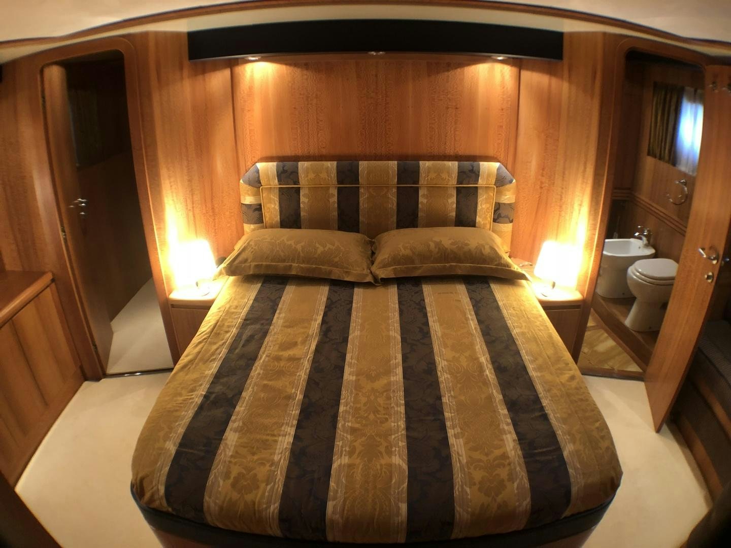 a bed with a black and white comforter and pillows aboard LADY J II Yacht for Sale