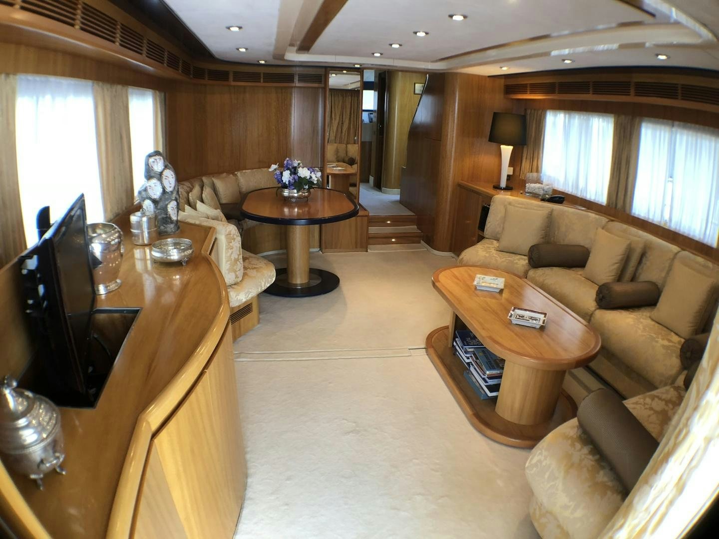 a living room with a table and couches aboard LADY J II Yacht for Sale