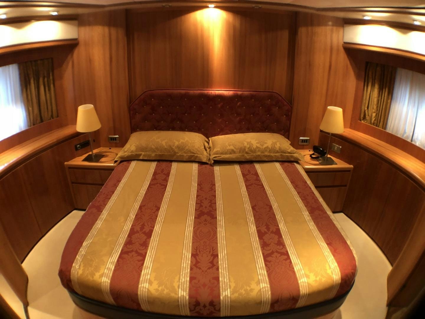 a bed with a red and yellow comforter aboard LADY J II Yacht for Sale