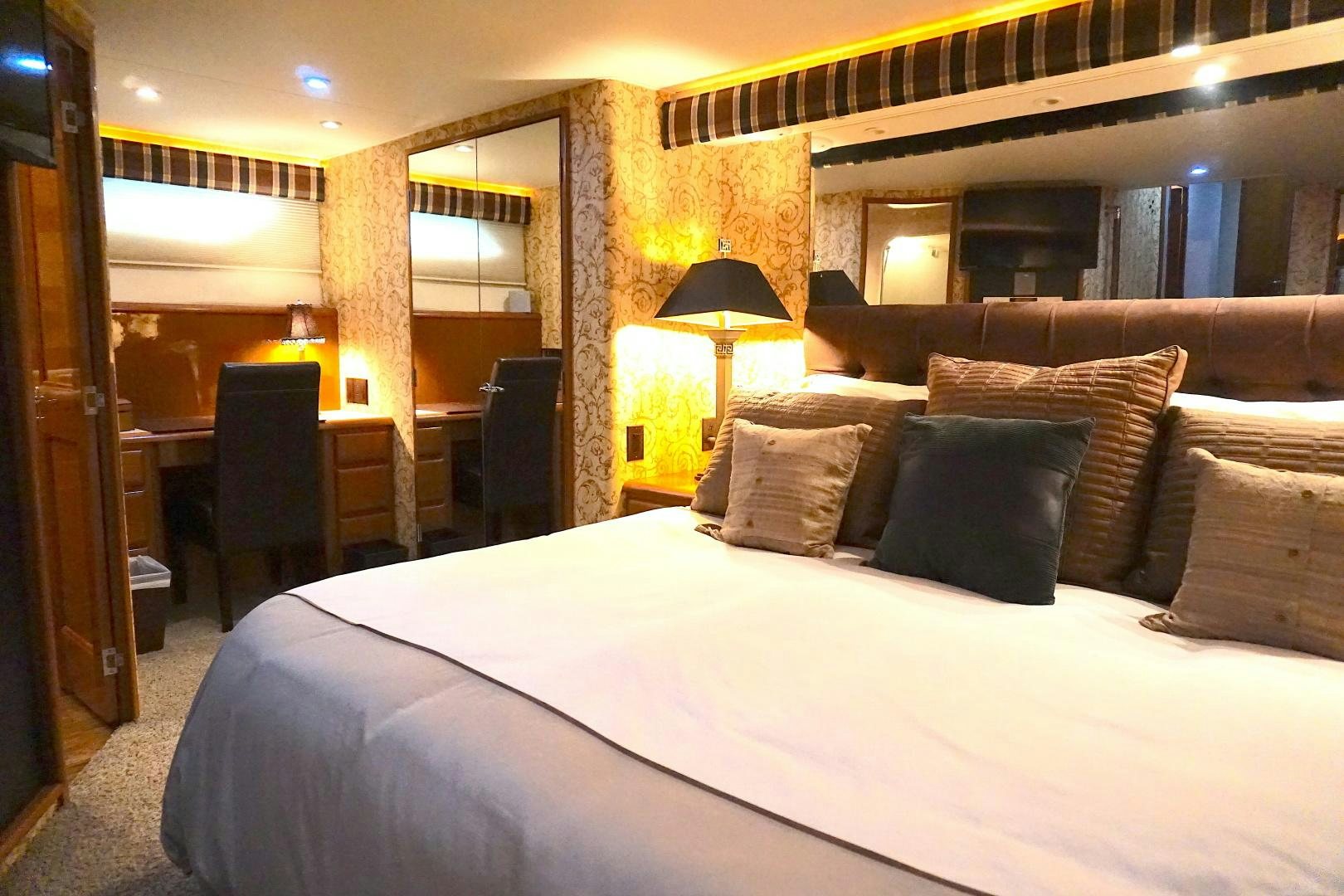 a bed with pillows and a lamp aboard CROWN ROYAL Yacht for Sale