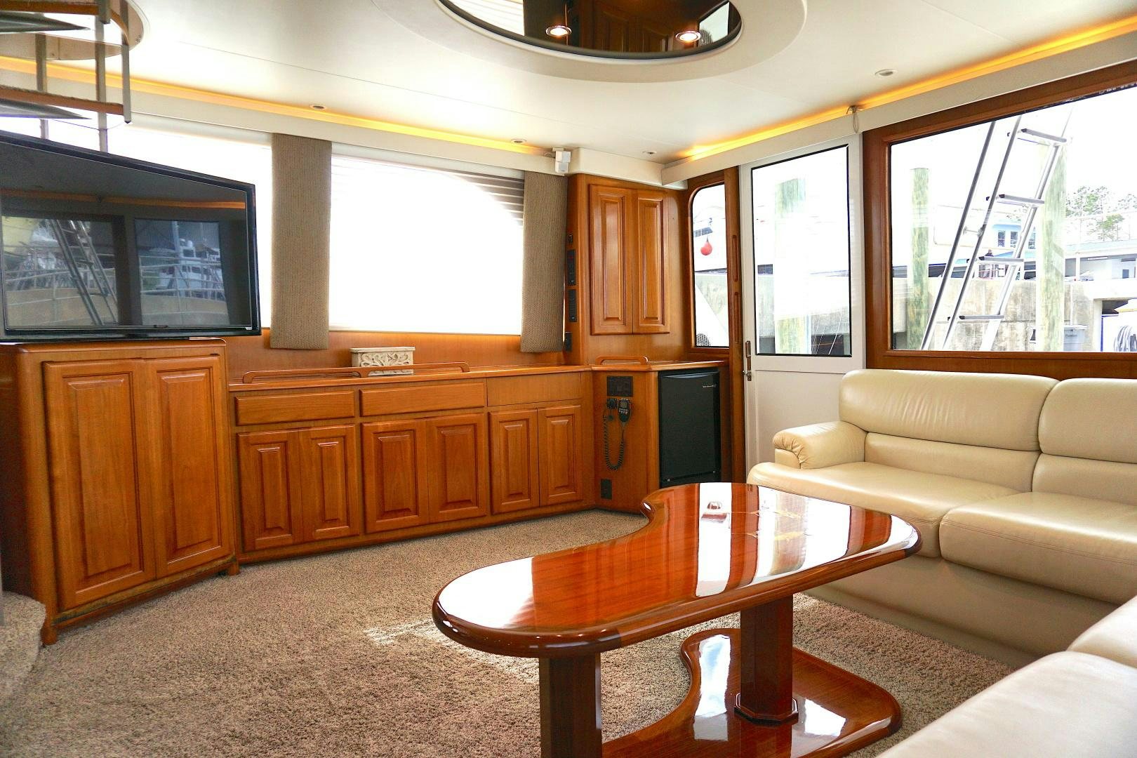 a living room with a table and a tv aboard CROWN ROYAL Yacht for Sale