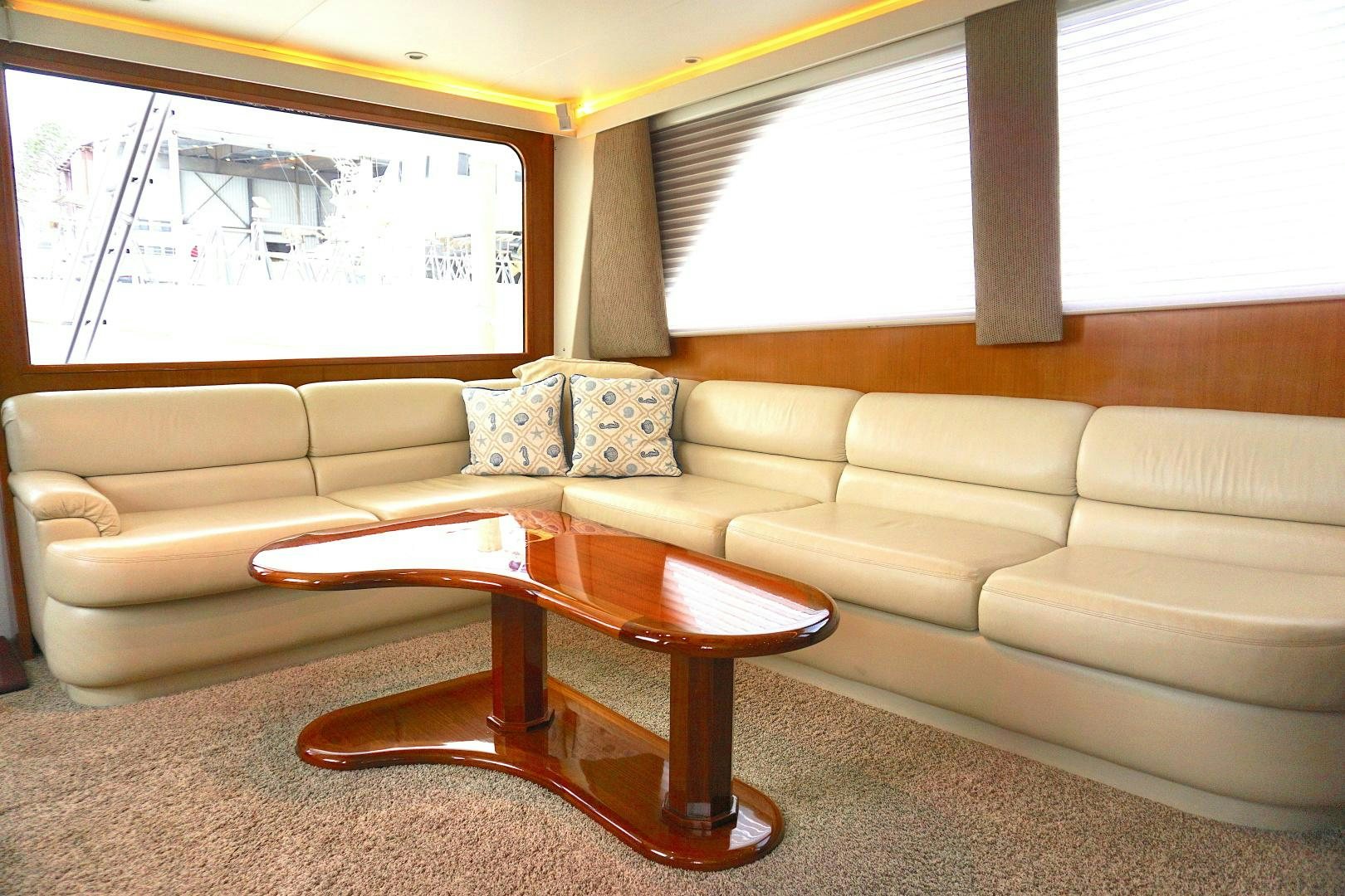 a living room with a couch and coffee table aboard CROWN ROYAL Yacht for Sale