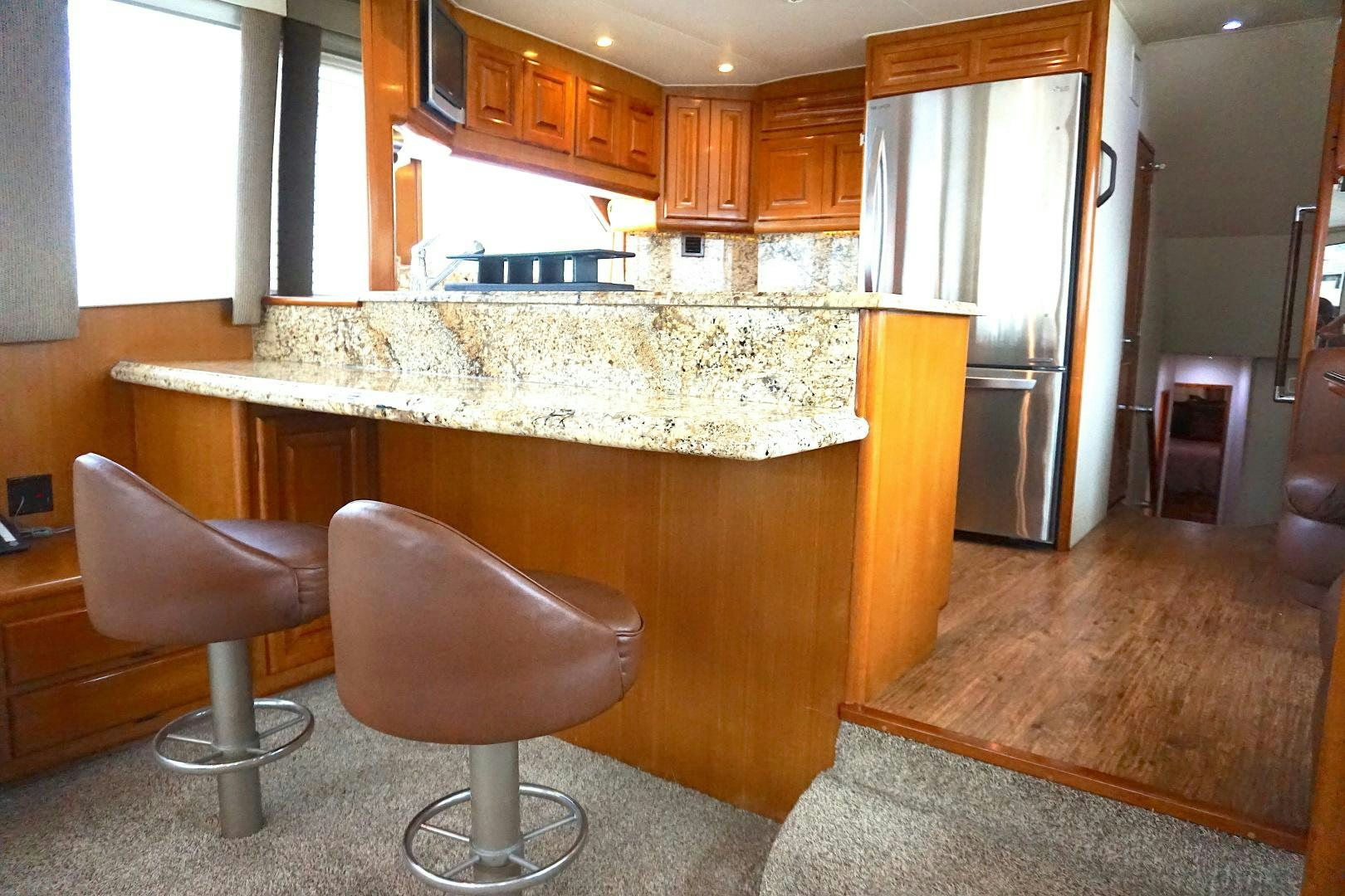 a kitchen with a bar and chairs aboard CROWN ROYAL Yacht for Sale