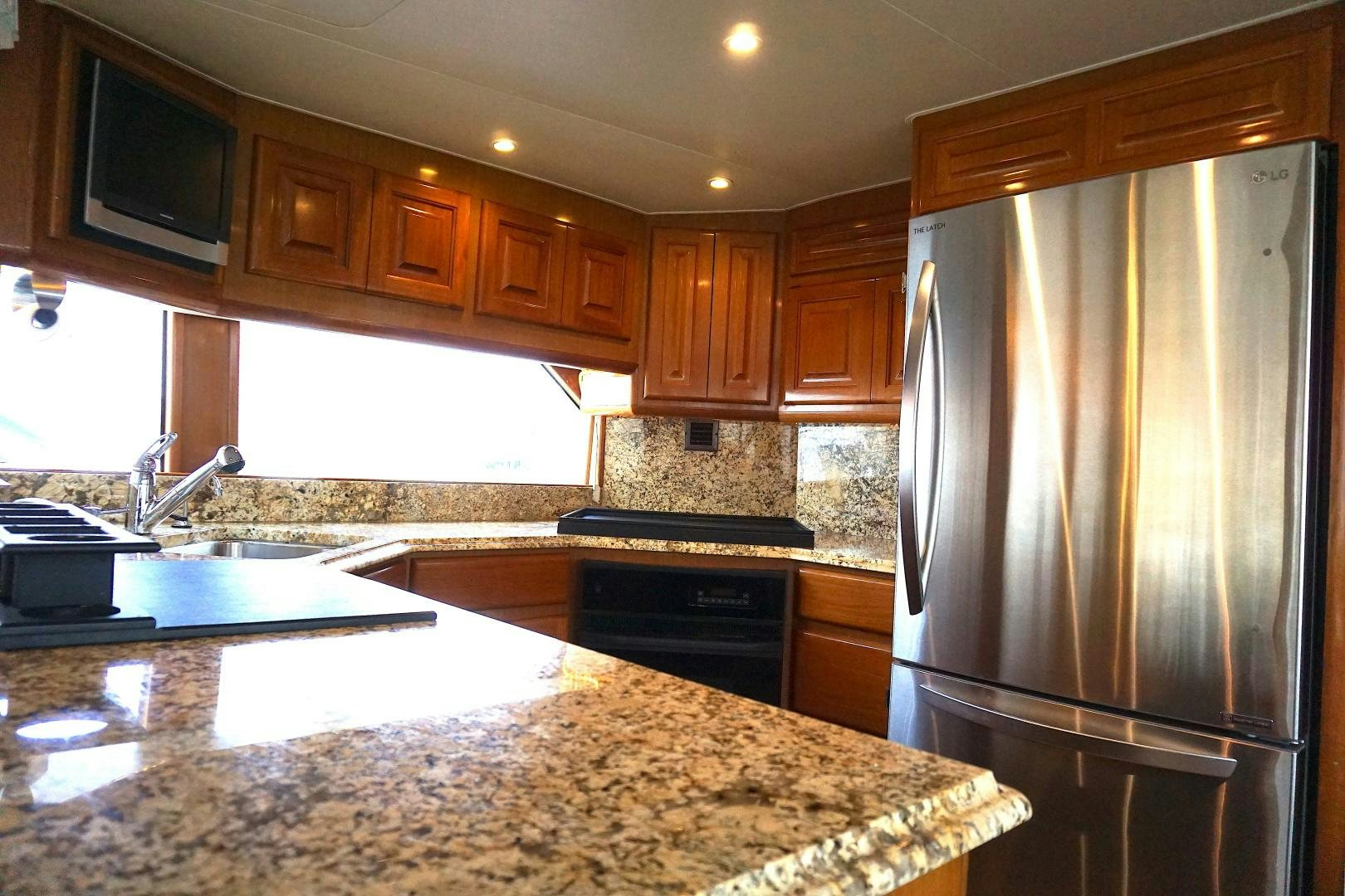 a kitchen with a stainless steel refrigerator aboard CROWN ROYAL Yacht for Sale