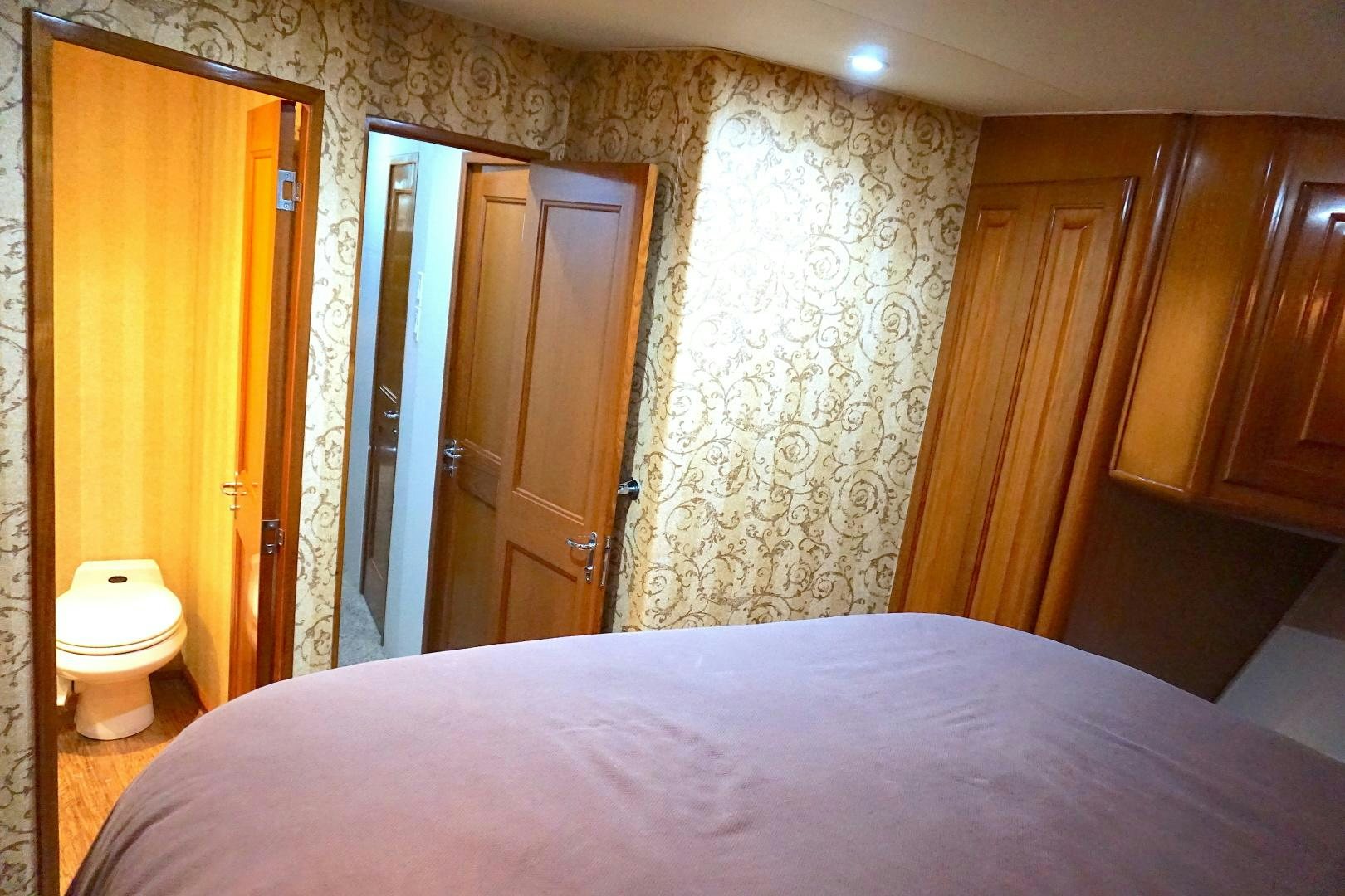 a bedroom with a bed and a closet aboard CROWN ROYAL Yacht for Sale