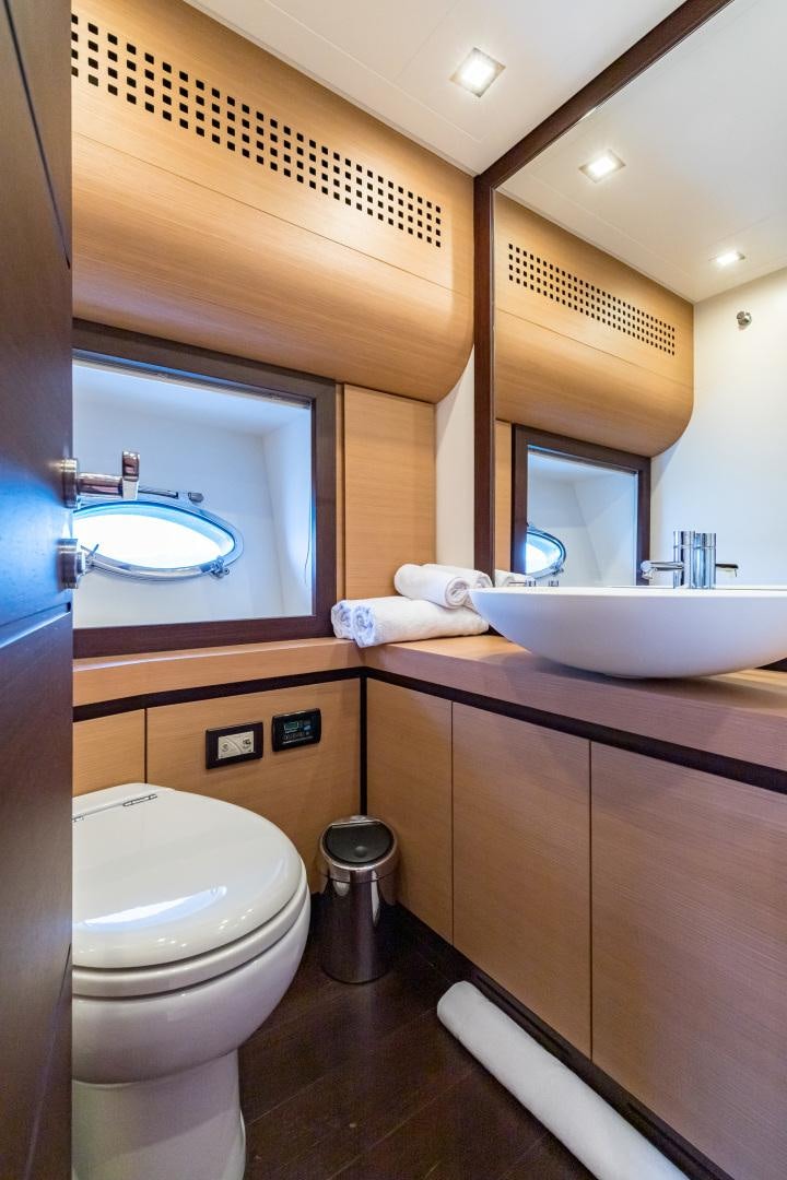 a bathroom with a sink toilet and a mirror aboard LOONEY Yacht for Sale