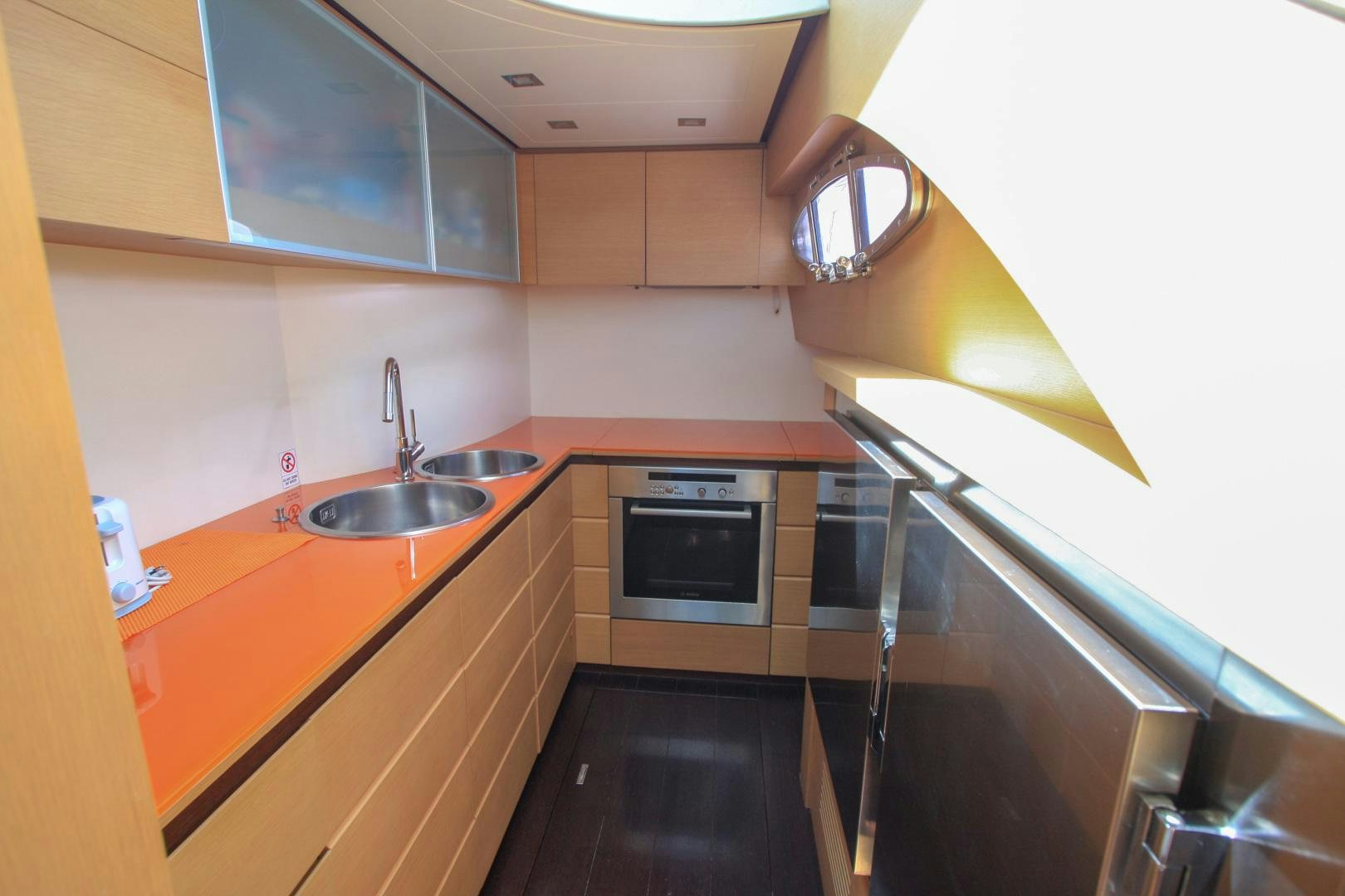 a kitchen with a steel stove and a sink aboard TOYZ4BOYZ Yacht for Sale