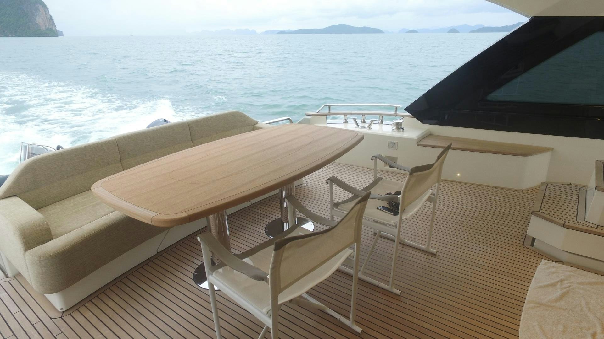 a deck with chairs and a table on it aboard WASANA Yacht for Sale