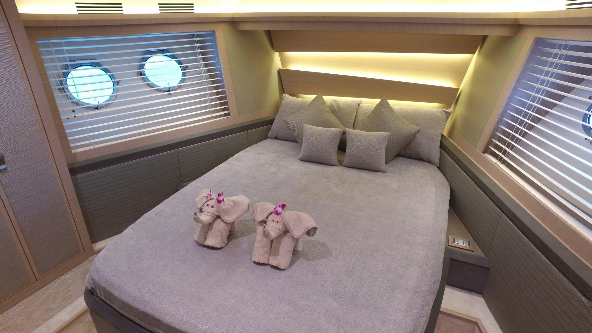 a bed with a purple comforter and pillows aboard WASANA Yacht for Sale