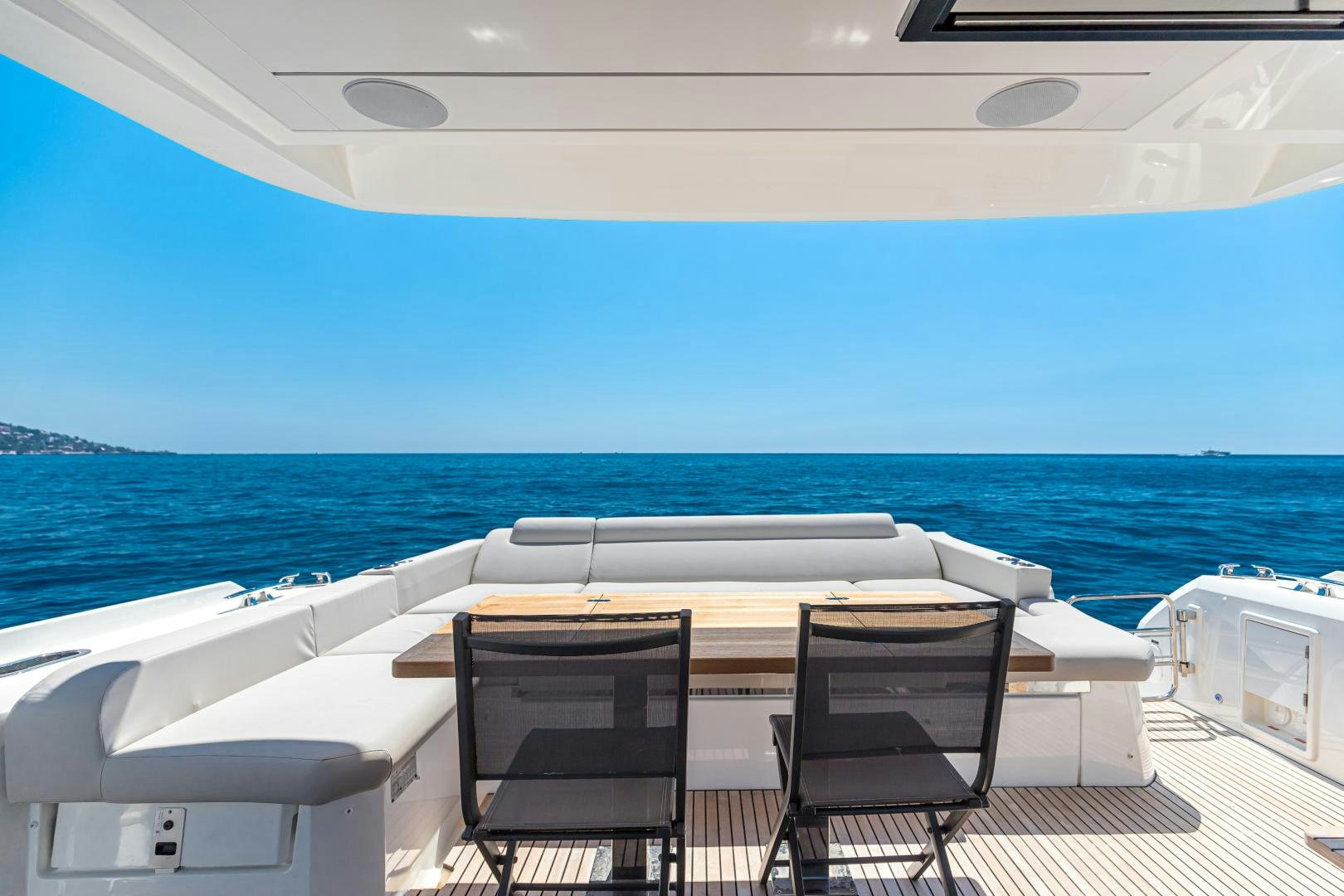 a table and chairs on a deck overlooking the ocean aboard LA HUNE 4.0 Yacht for Sale