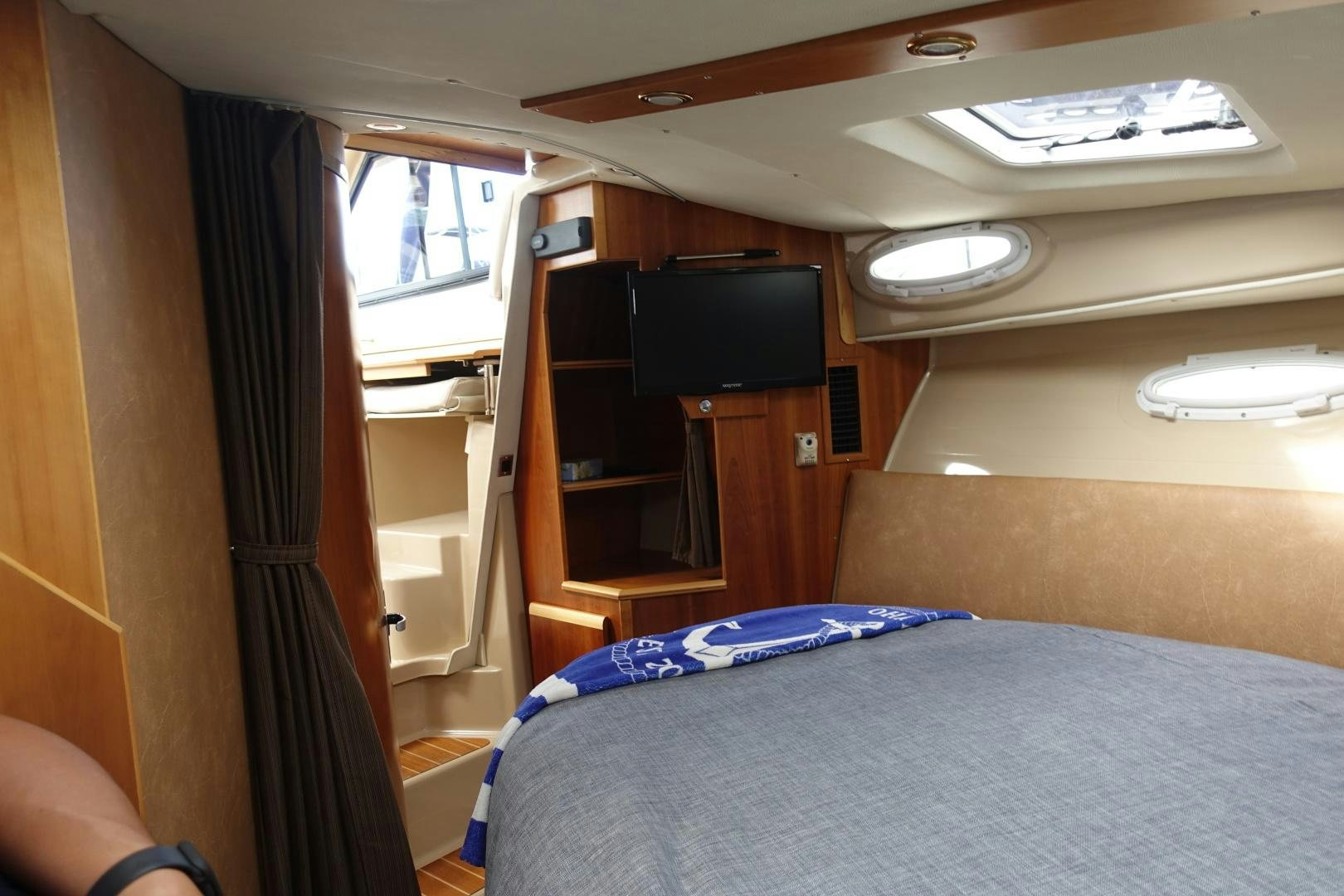 a bedroom with a bed and a tv aboard OHANA Yacht for Sale