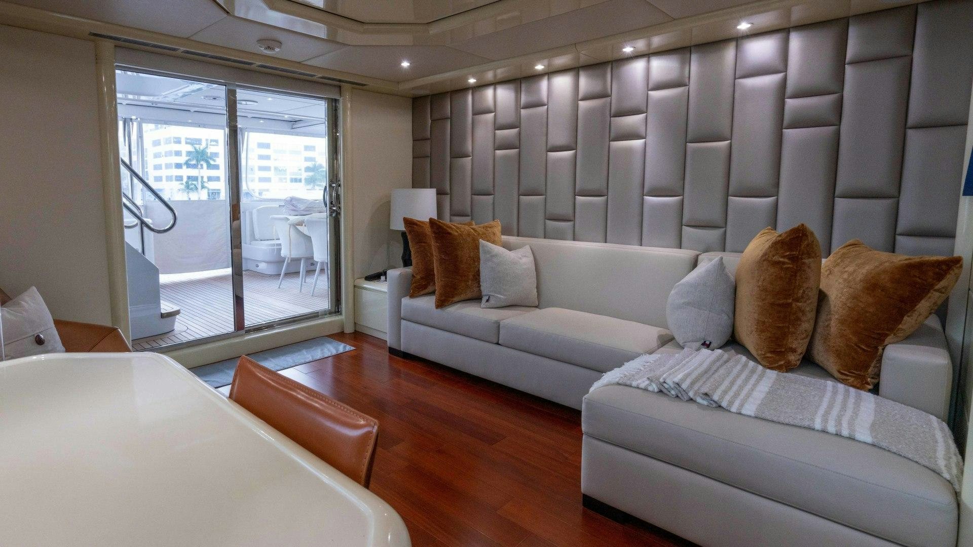 a living room with a couch and a large window aboard THE PEARL Yacht for Sale