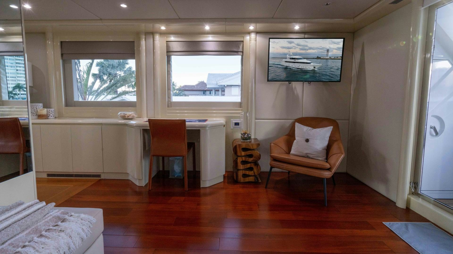 a room with a wood floor and a chair and a desk with a window and a chair aboard THE PEARL Yacht for Sale