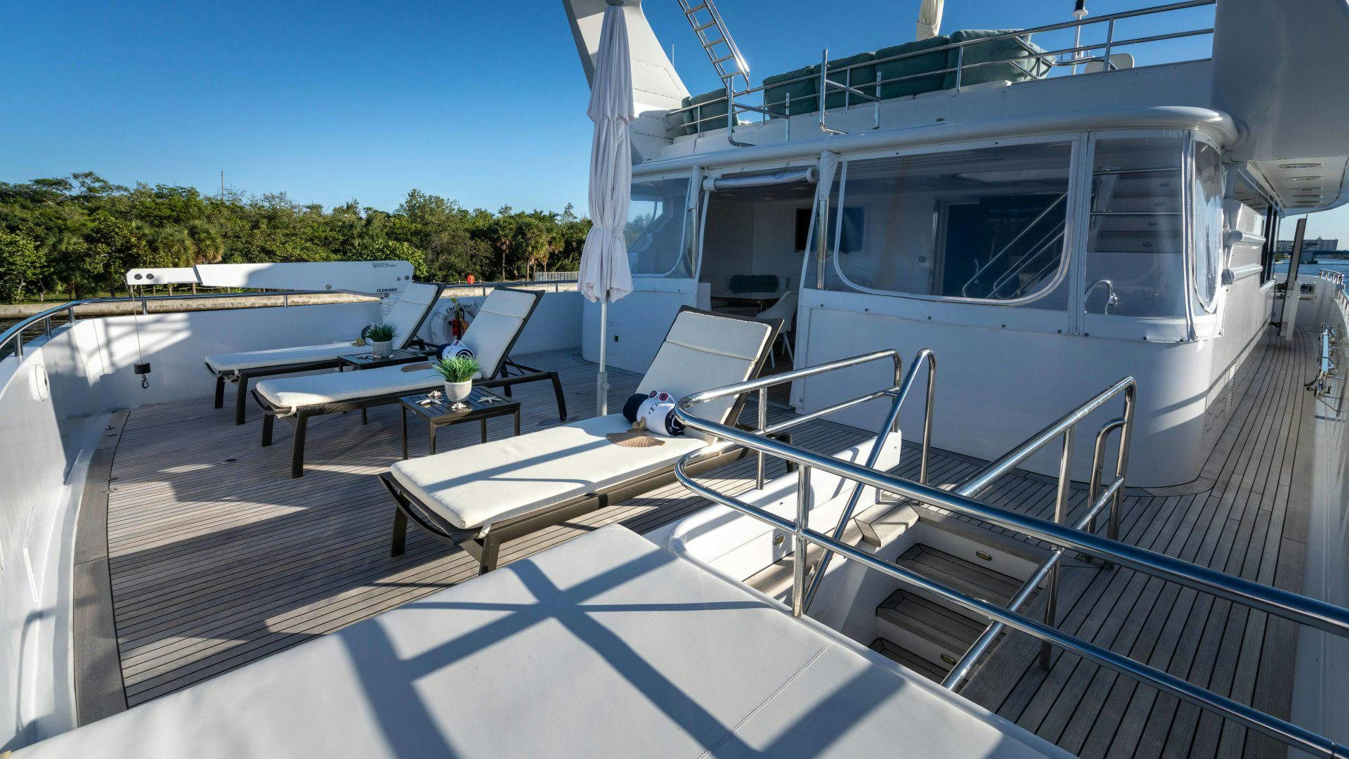 a deck with a table and chairs on it aboard THE PEARL Yacht for Sale