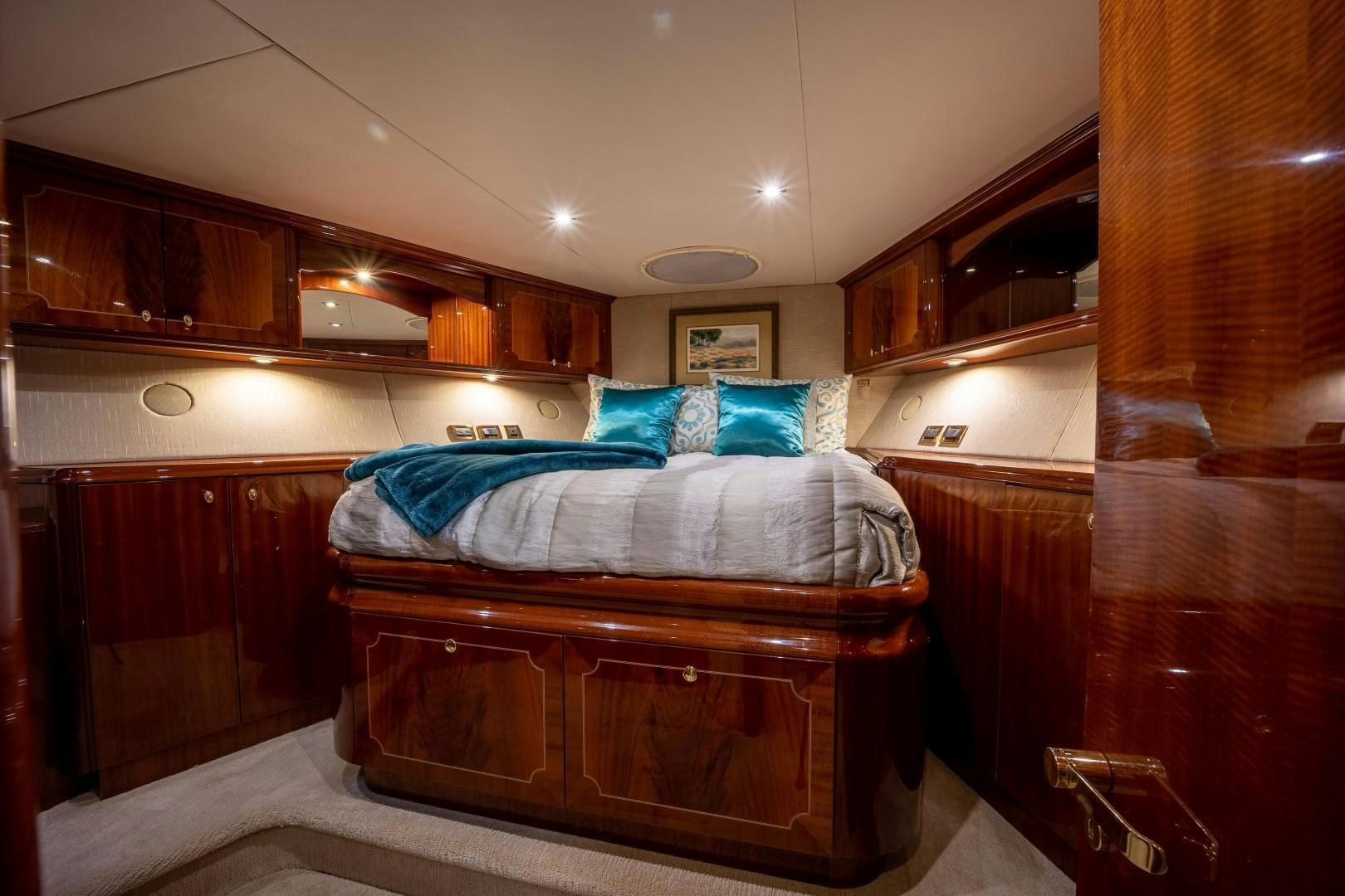 a bedroom with a bed and a wood cabinet aboard PASSION Yacht for Sale