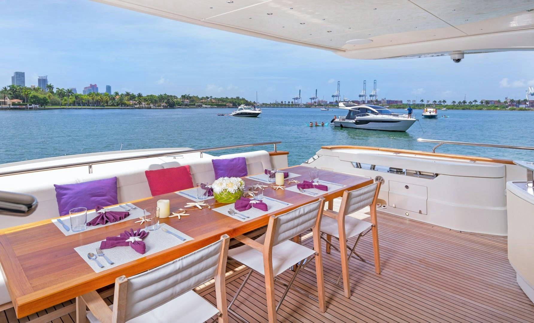a table and chairs on a deck overlooking a body of water aboard CASUAL Yacht for Sale