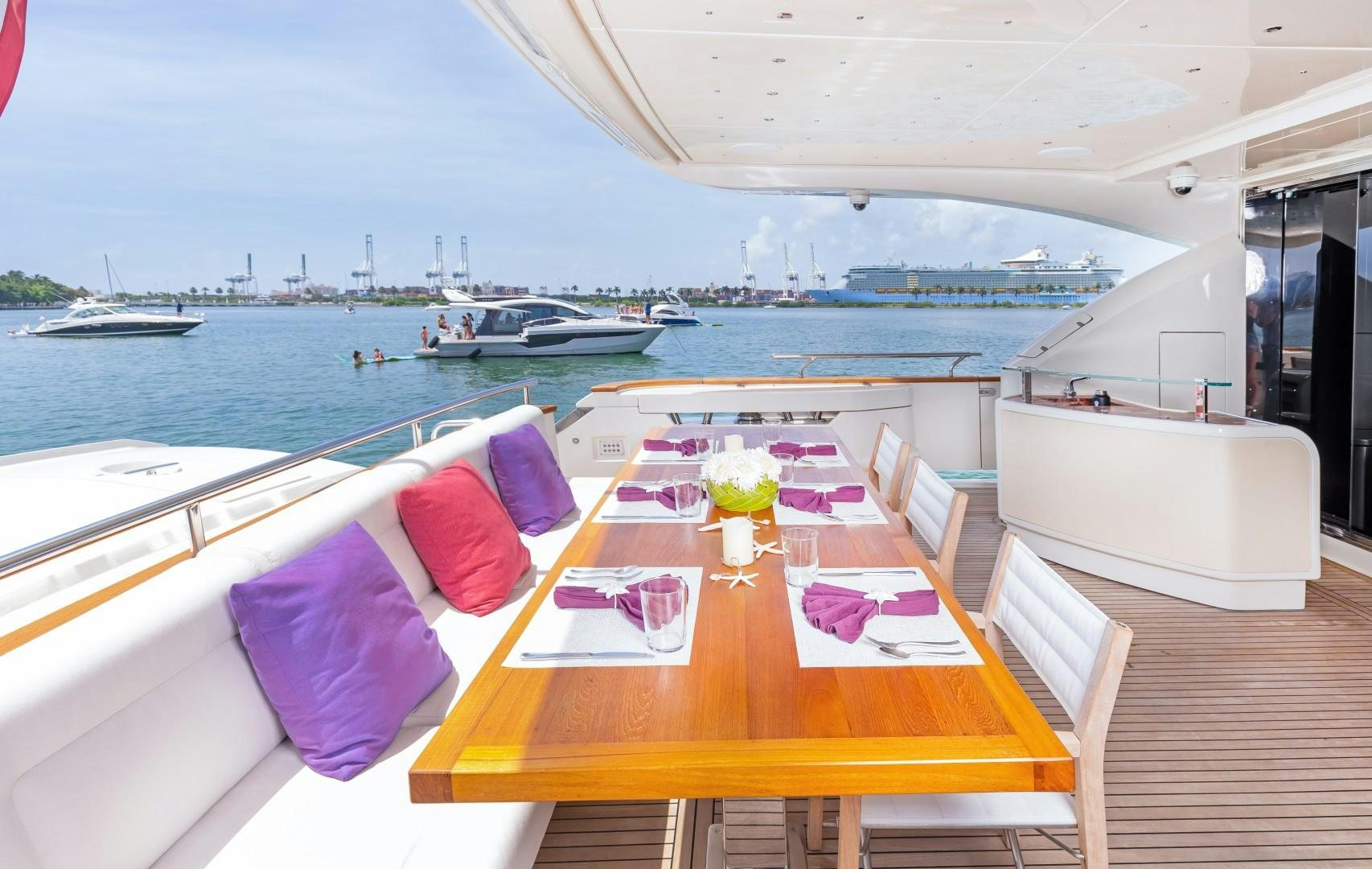 a table with purple cloths on it and a boat in the water aboard CASUAL Yacht for Sale