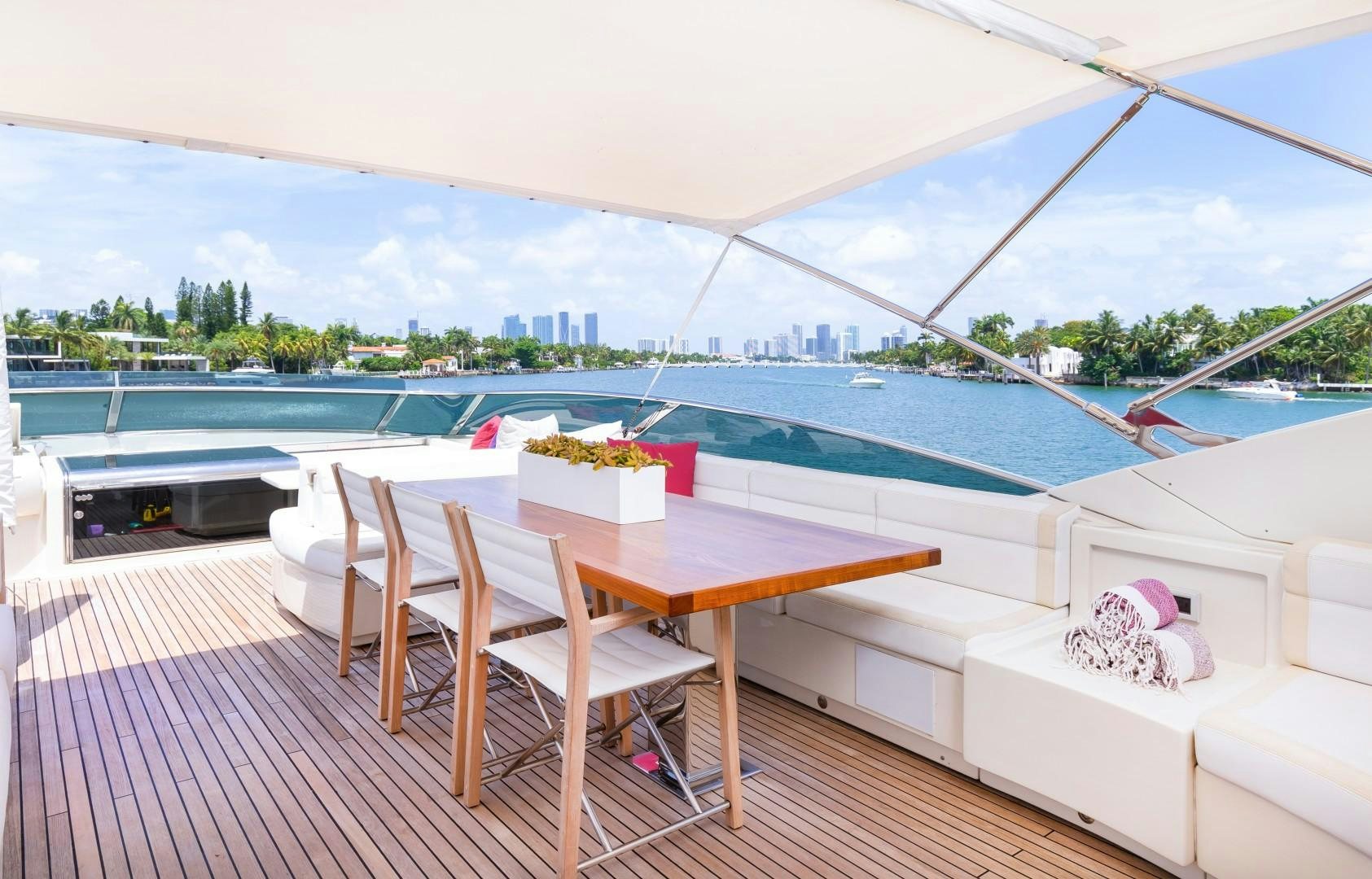 a table and chairs on a deck overlooking a pool aboard CASUAL Yacht for Sale