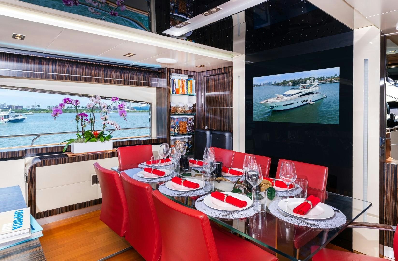a dining room with red tables and chairs aboard CASUAL Yacht for Sale