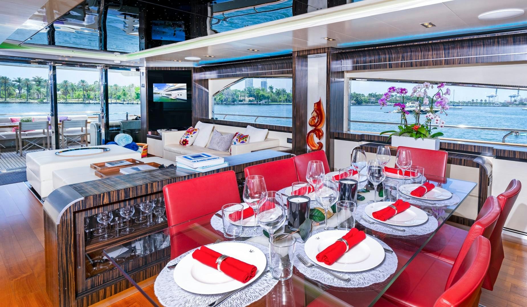 a dining room with red chairs and tables aboard CASUAL Yacht for Sale