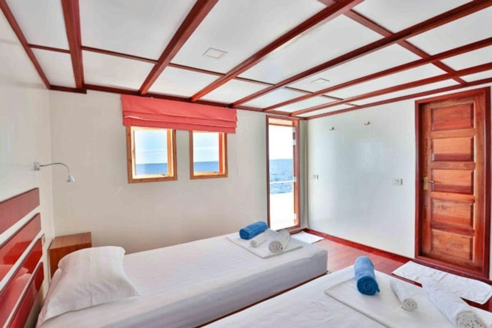 a bedroom with a bed and a window aboard KEANA Yacht for Sale
