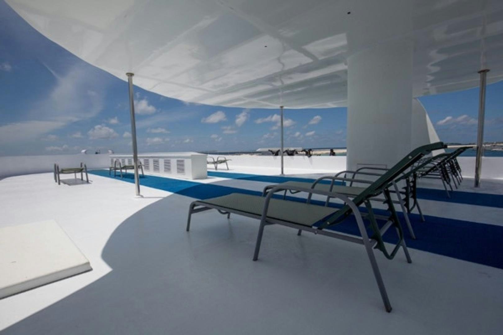 a pool with chairs and a table aboard KEANA Yacht for Sale