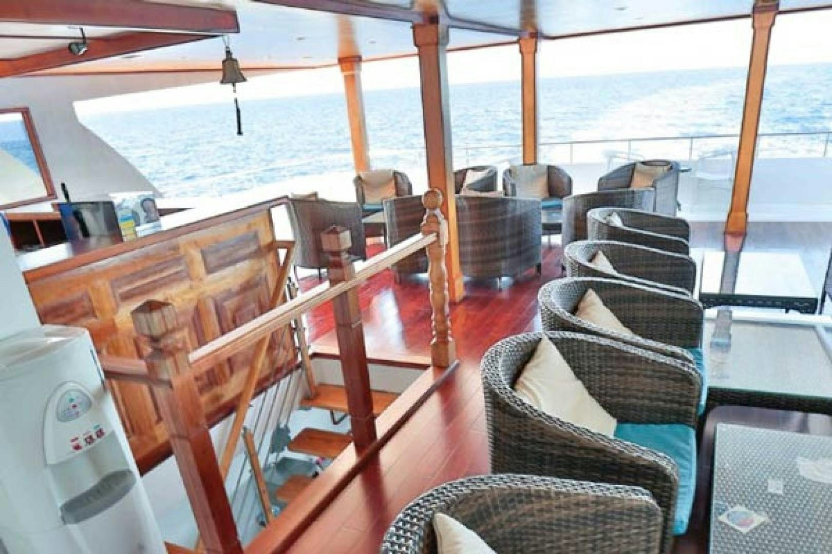 a boat with wood decking and wood railings and a body of water aboard KEANA Yacht for Sale