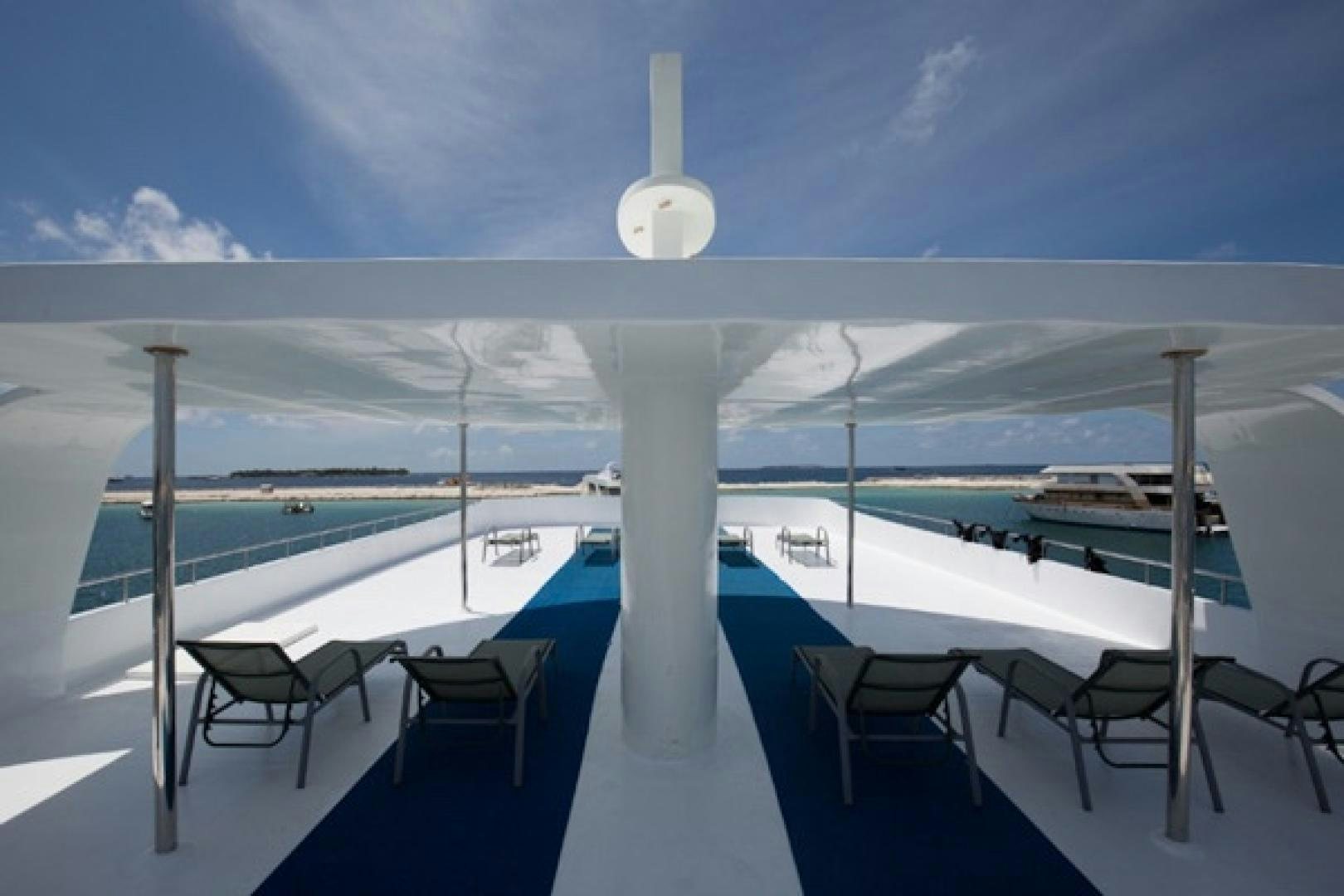 a pool with chairs and a large white pole on a sunny day aboard KEANA Yacht for Sale