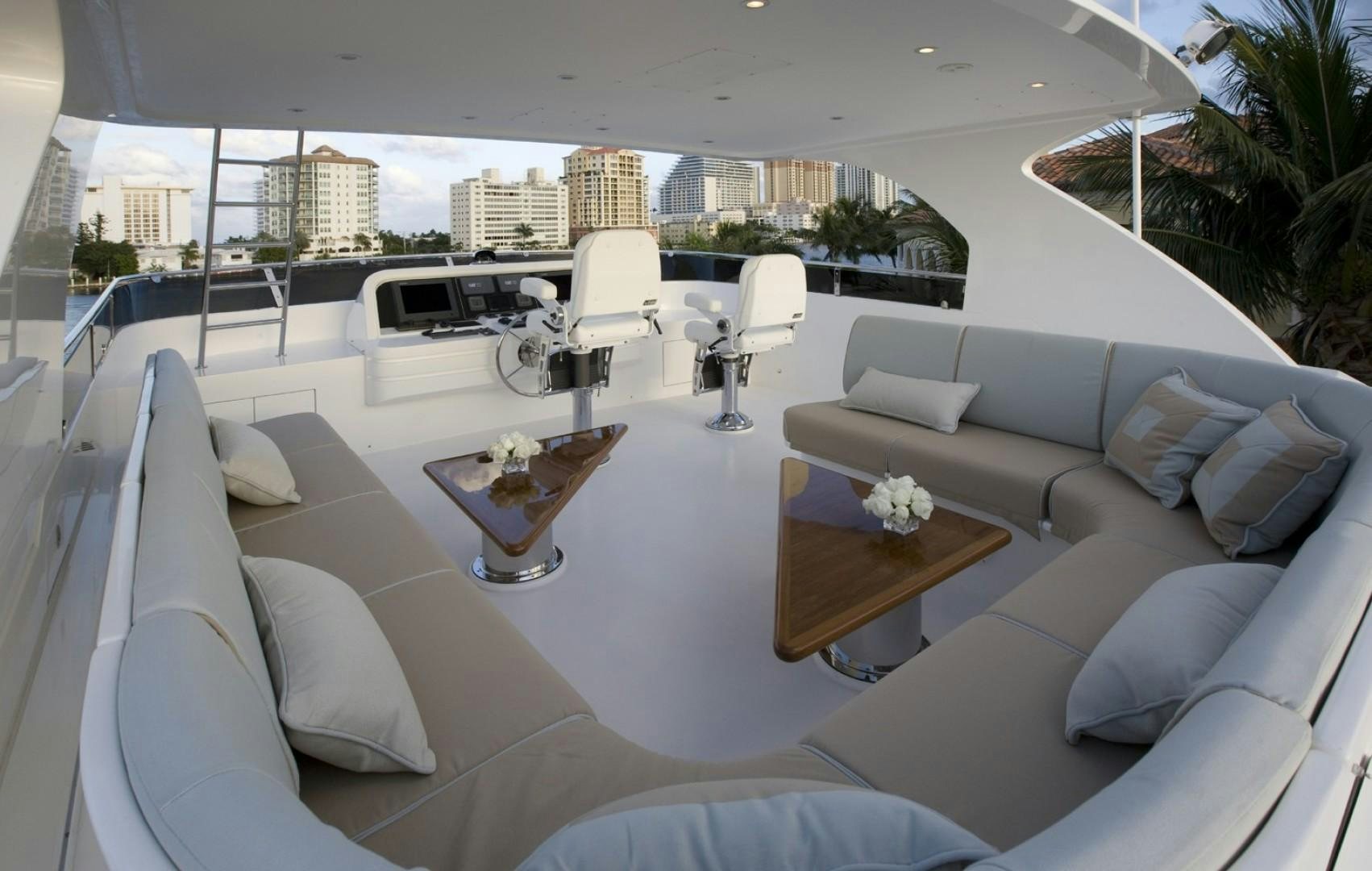 a large white lounge chair in a room with a large white sofa and a table with chairs and aboard GLEN ELLEN Yacht for Sale