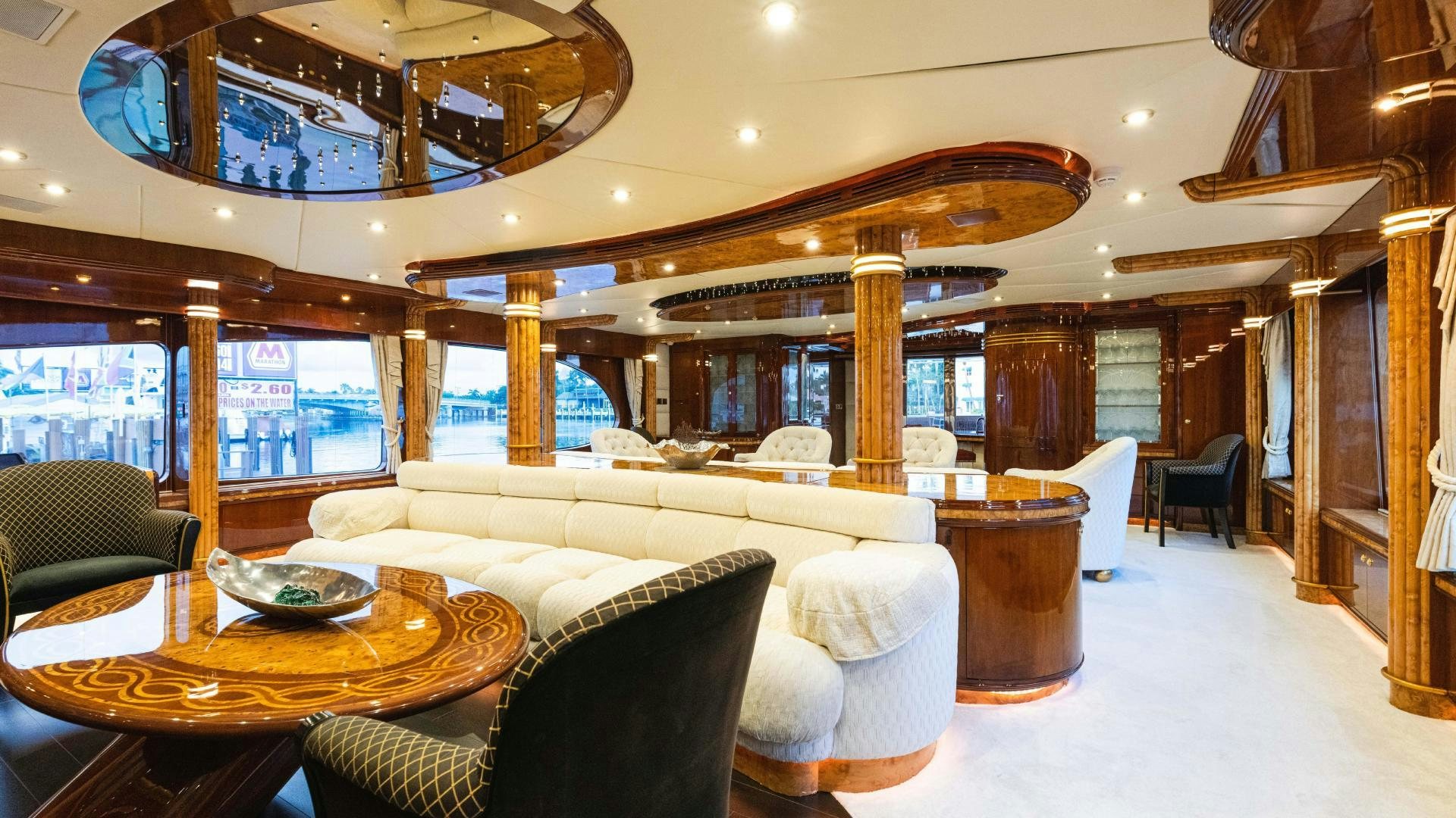 a large living room with a large wood table and chairs aboard SEA ALICE I Yacht for Sale