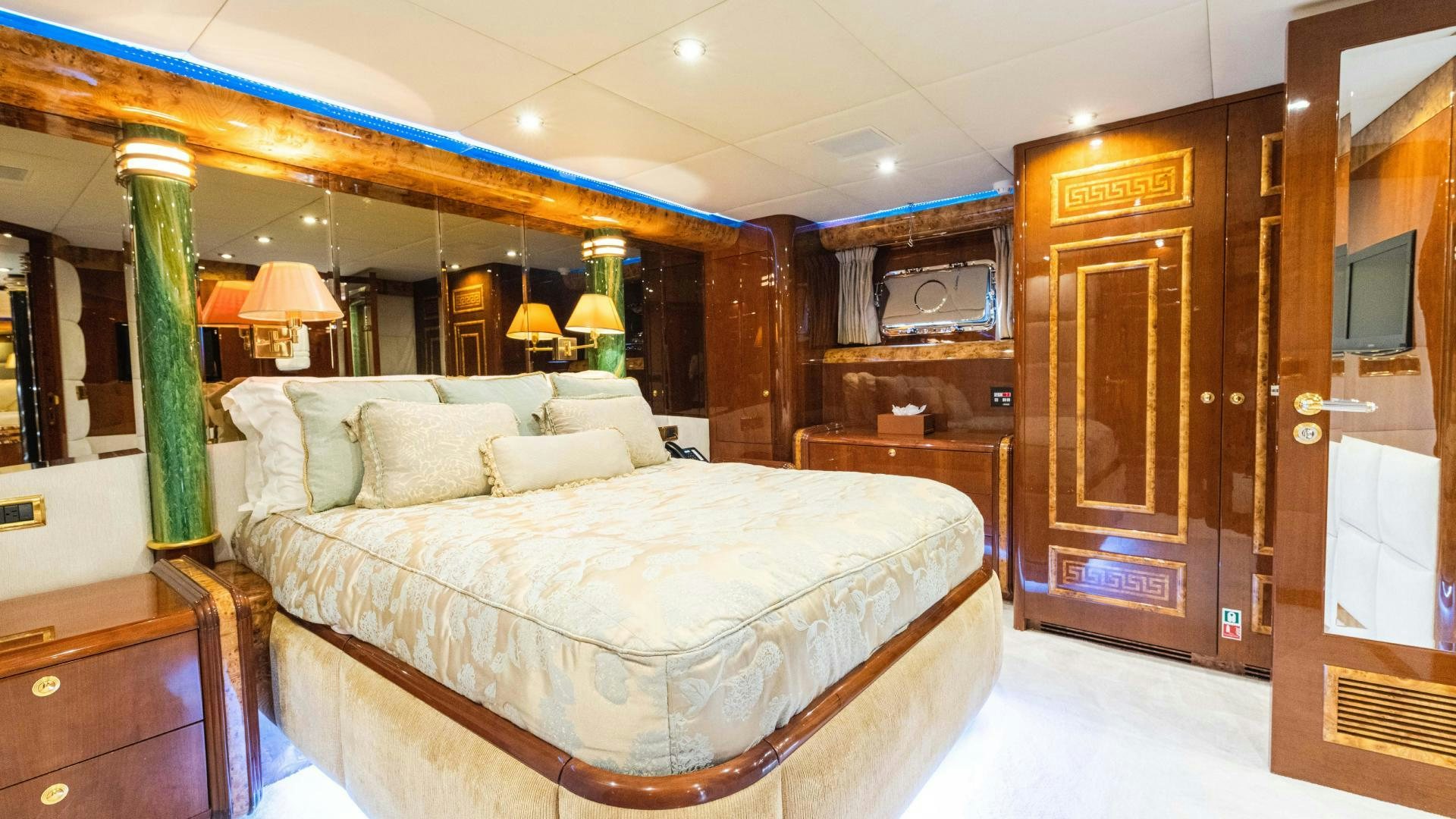 a bedroom with a bed and a wood door aboard SEA ALICE I Yacht for Sale