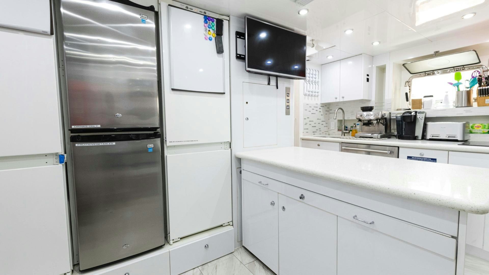 a kitchen with white cabinets aboard SEA ALICE I Yacht for Sale