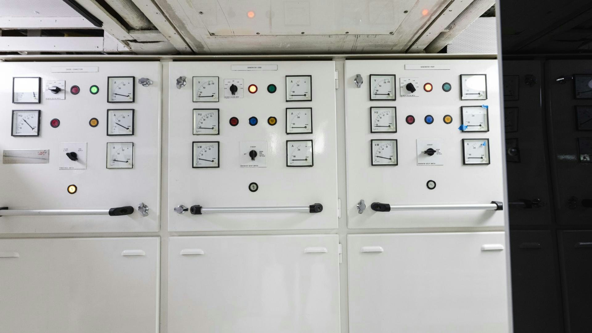 a white panel with black and red buttons and switches aboard SEA ALICE I Yacht for Sale