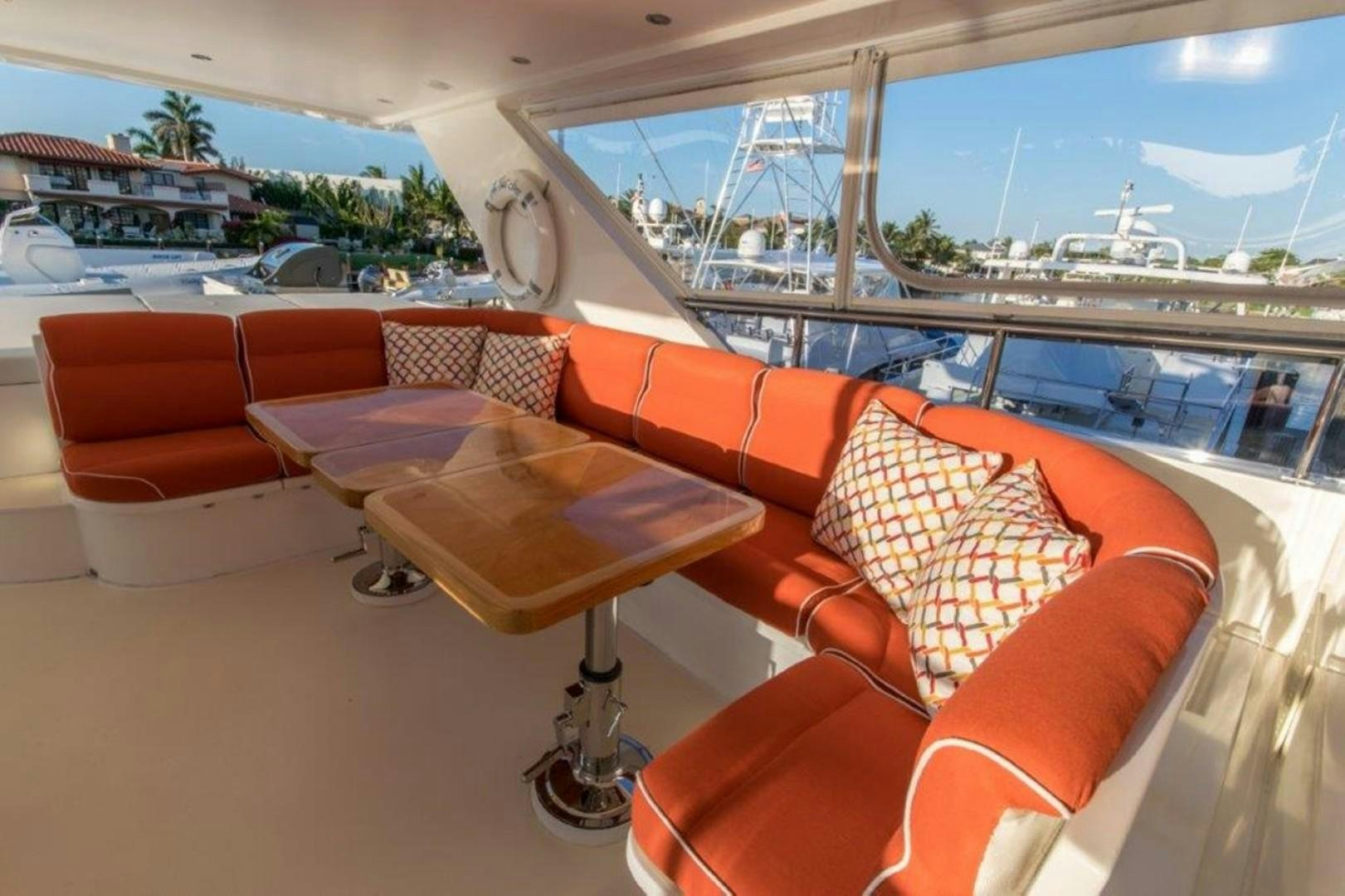 a room with orange couches and a large window overlooking a body of water aboard MISS DUNIA Yacht for Sale
