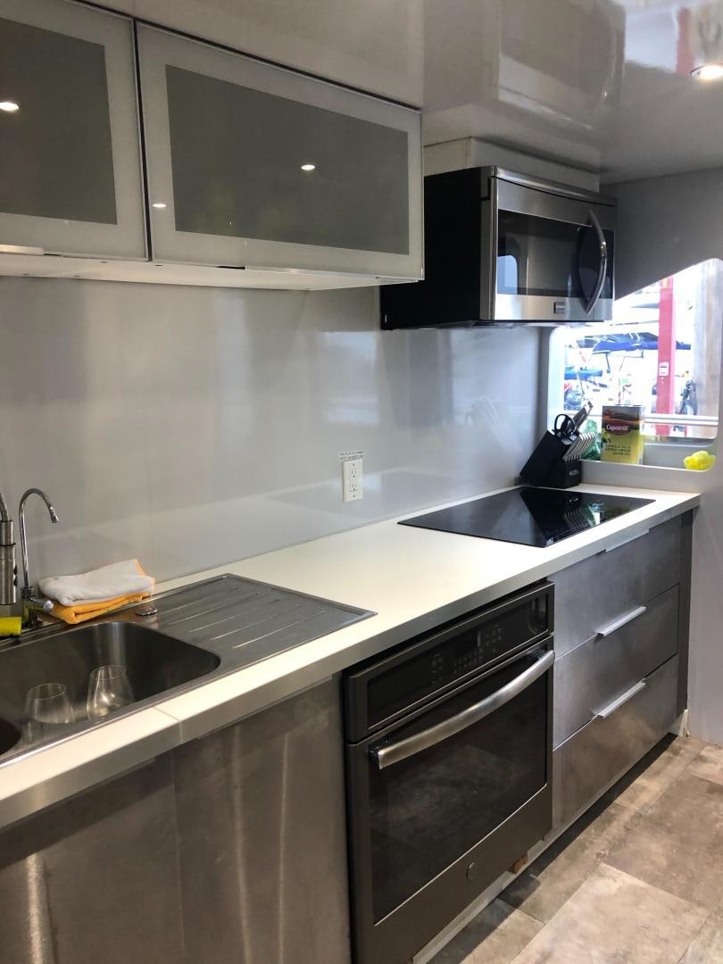 a kitchen with a black stove and a black microwave aboard NIRVANA Yacht for Sale