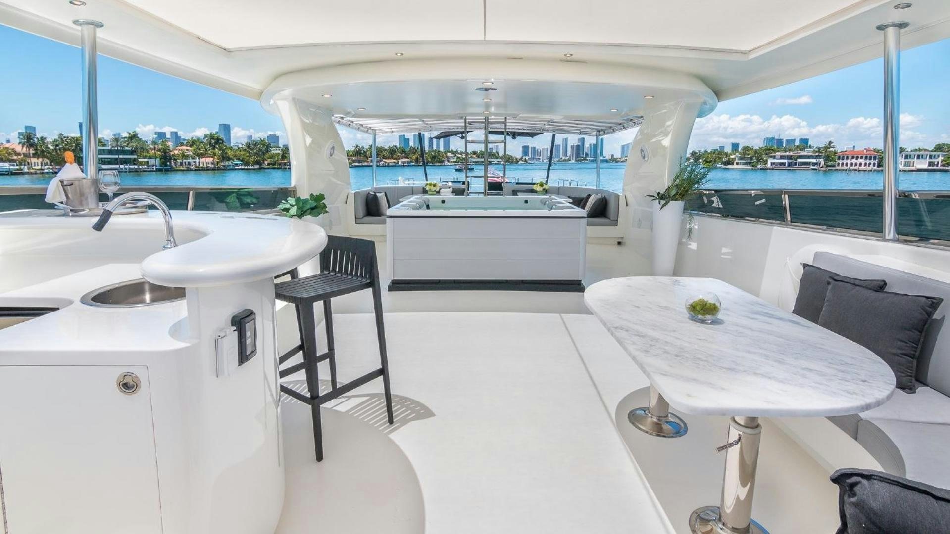 a white kitchen with a table and chairs aboard NIRVANA Yacht for Sale